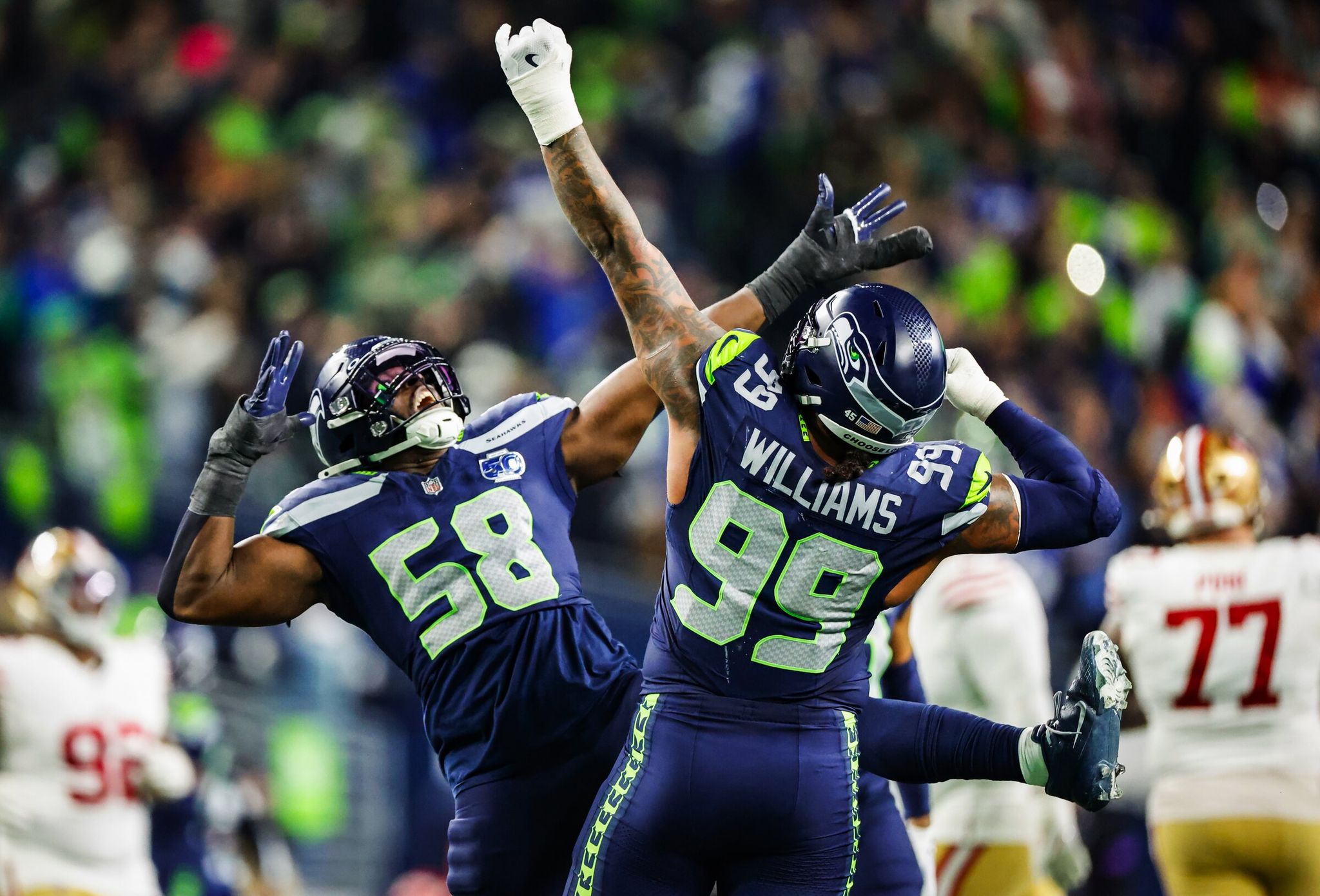 Seattle Seahawks linebacker Derrick Hall, left, celebrates with defensive end Leonard Williams after Williams recorded a sack on San Francisco 49ers quarterback Brock Purdy in the third quarter of the divisional playoff on Saturday, Jan. 17, 2026, at Lumen Field in Seattle. (Dean Rutz / The Seattle Times)