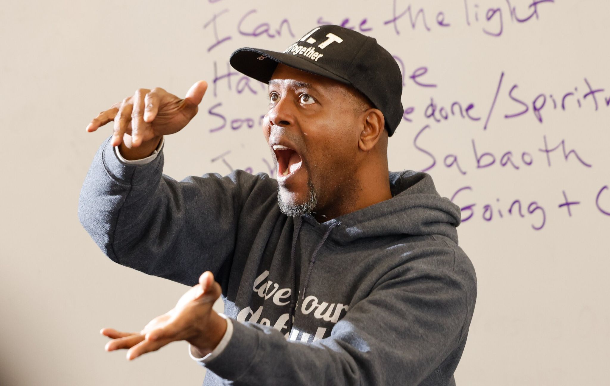 Marshawn Moultrie, co-founder and artistic director of Resounding Love Center for the Arts, leads rehearsal at South Seattle College on Saturday. The racially diverse choir believes in 'radical inclusion and social connection through music.' (Karen Ducey / The Seattle Times)