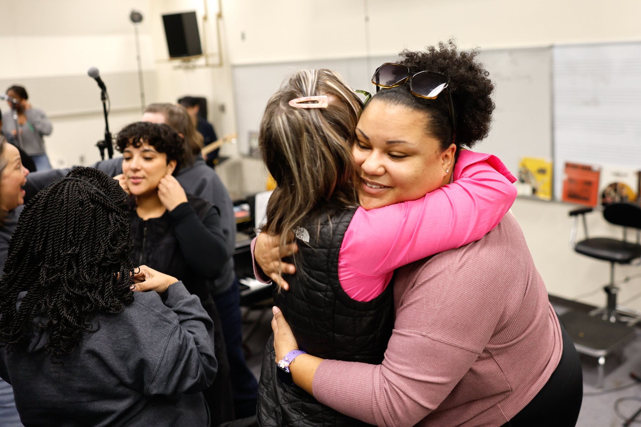 Resounding Love choir members Aaliyah Bains (right) and Kim Becklund embrace at the start of rehearsal at South Seattle College. (Karen Ducey / The Seattle Times)