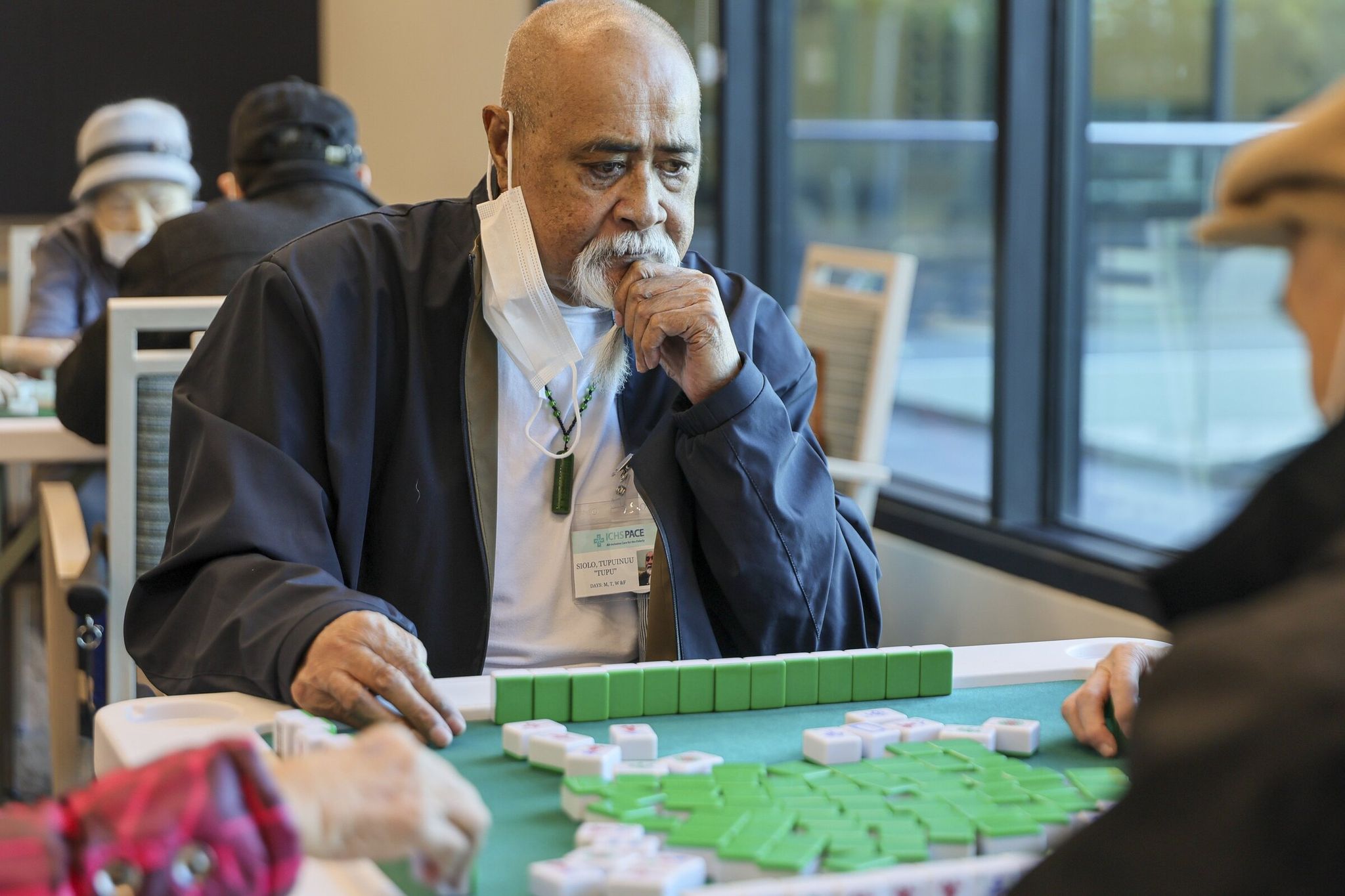 Tupuinuu “Tupu” Siolo says regular physical therapy and exercise programs have made him stronger. On this day his time at the center included a game of mahjong. (Kevin Clark / The Seattle Times)