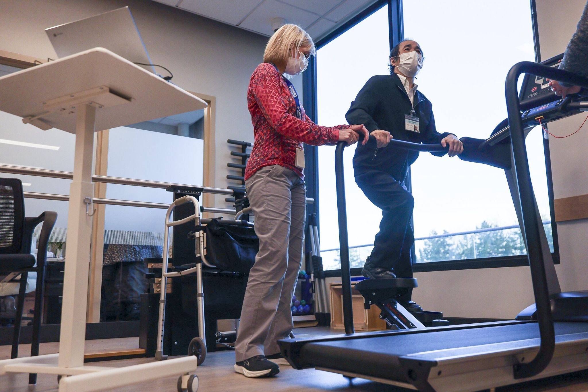 Linda MacAllister works with Paul Lee during physical therapy. (Kevin Clark / The Seattle Times)