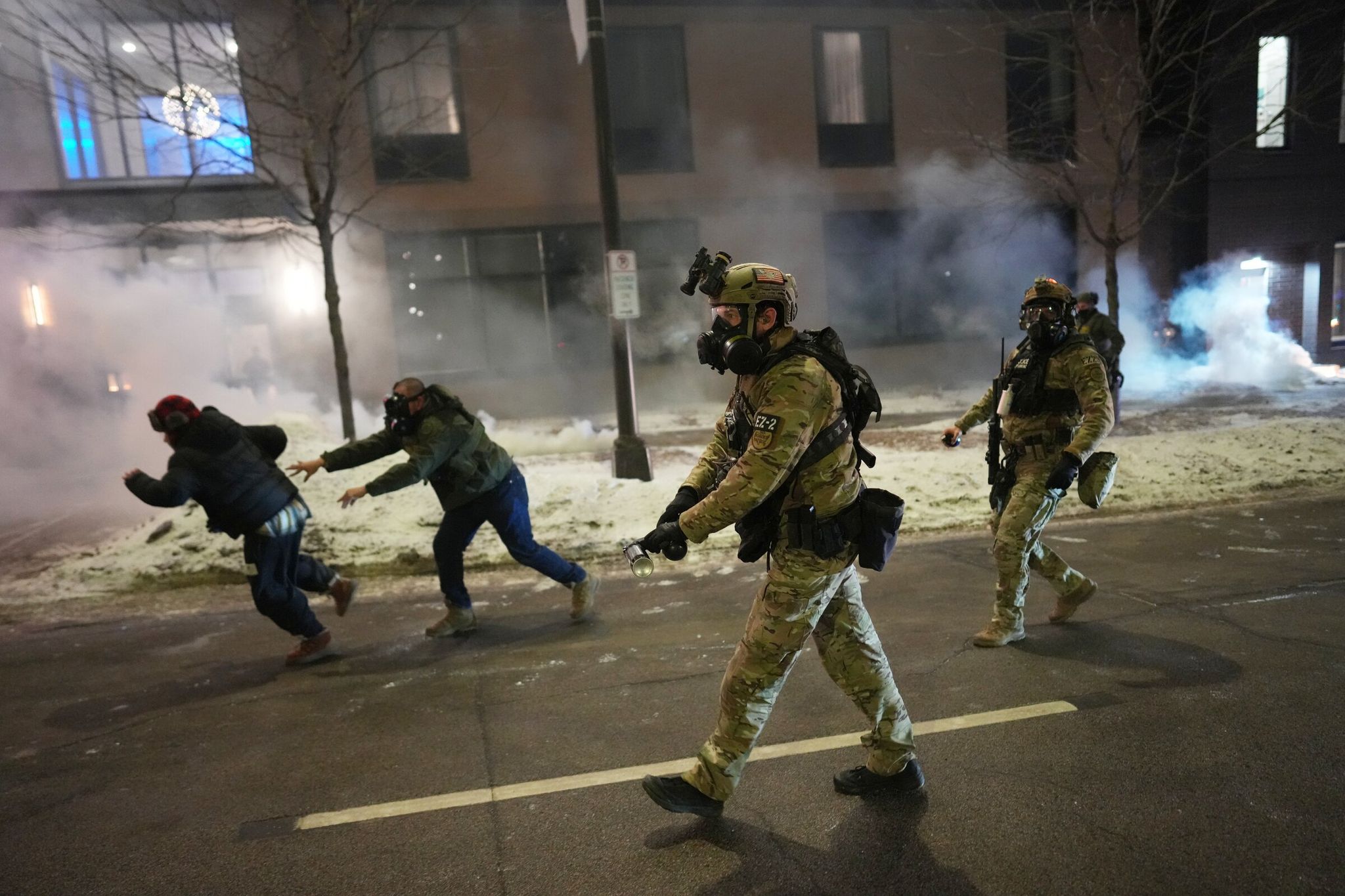 Federal agents try to disperse demonstrators near a hotel in Minneapolis on Sunday. (Adam Gray / Associated Press)