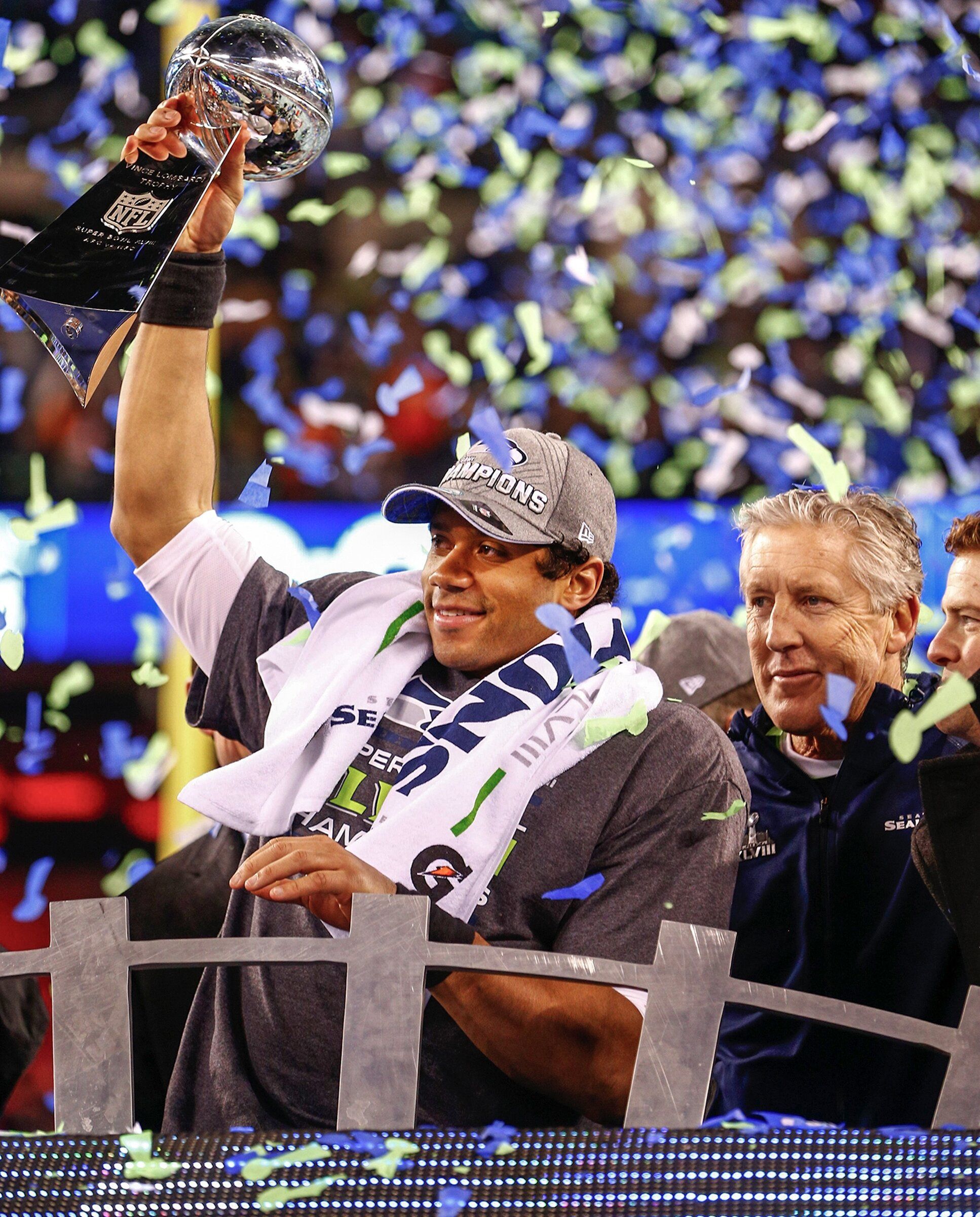 Russell Wilson holds the Lombardi Trophy as Pete Carroll watches after the Seahawks won Super Bowl XLVIII at MetLife Stadium in East Rutherford, N.J., Feb. 2, 2014. (John Lok / The Seattle Times)