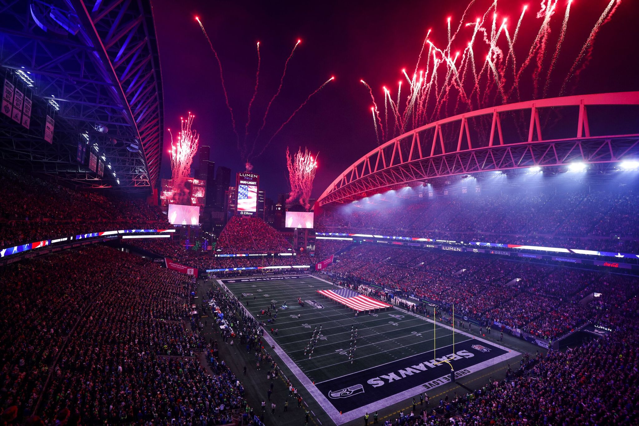 Large flags and fireworks — part of the NFL atmosphere, shown here before the Seahawks-49ers playoff game on Jan. 17 in Seattle. (Nick Wagner / The Seattle Times)