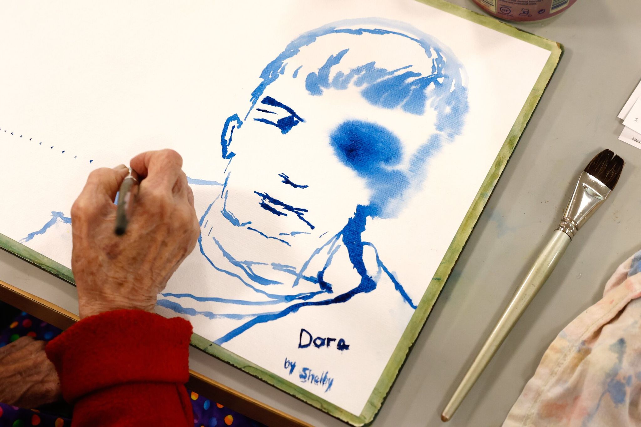 Shelby Benson paints a portrait of Dora, seated across from her, during a session for older adults with memory problems and dementia while they listen to the Balourdet String Quartet at the Memory Hub in Seattle last month. Some research focuses on how music can positively affect people beginning to experience memory or cognitive difficulties. (Karen Ducey / The Seattle Times)