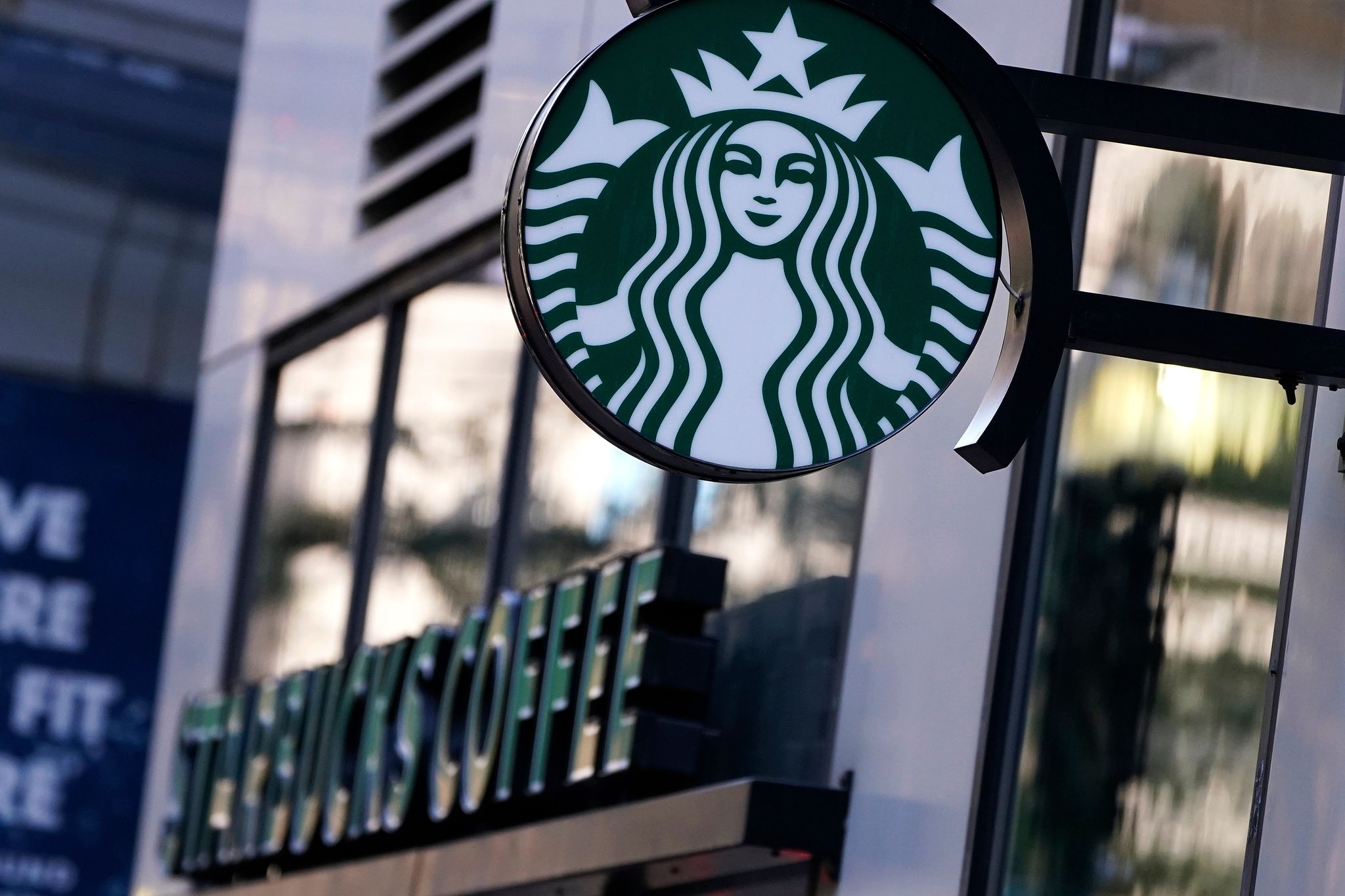 FILE — The ‘Siren’ logo hangs outside a Starbucks store, Wednesday, July 14, 2021, Boston. (AP Photo/Charles Krupa, File)