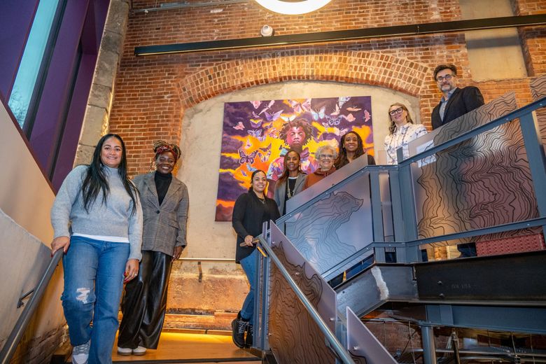 NOW: Tenants and project managers gather on the brightly lit lobby stairwell. (Jean Sherrard)