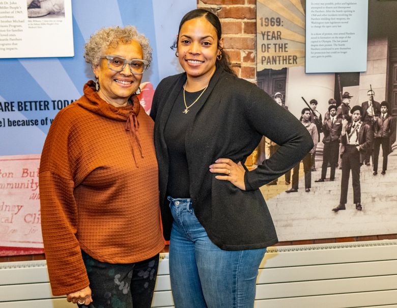 NOW: Ruby Love, left, and Naudia Miller of the Seattle Chapter Black Panther Party Legacy Group stand in their first-floor space, which features a history of the organization. (Jean Sherrard)