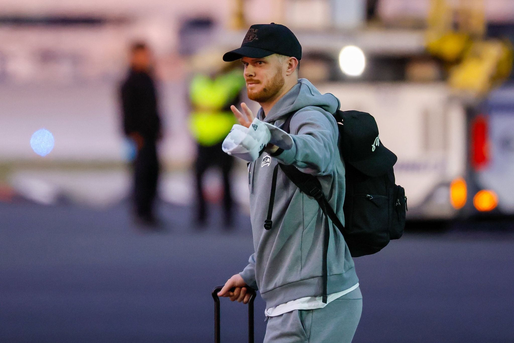 Seahawks quarterback Sam Darnold waved after the team arrived at San José airport on Sunday. (Jennifer Buchanan / The Seattle Times)