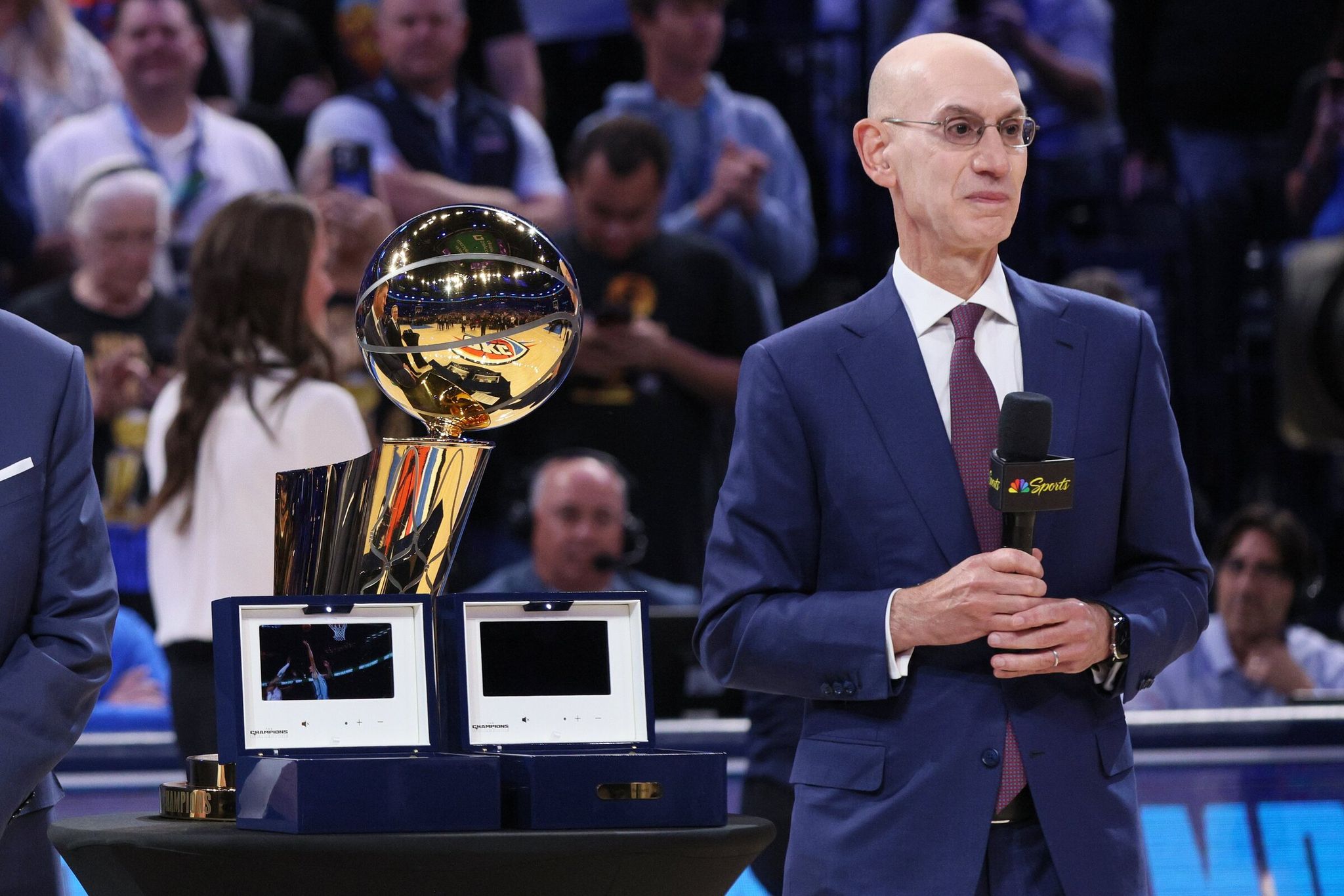 NBA commissioner Adam Silver stands beside the Larry O’Brien Trophy during a pregame ceremony before an NBA game between the Houston Rockets and the Oklahoma City Thunder, Oct. 21, 2025, in Oklahoma City. (Nate Billings / AP)