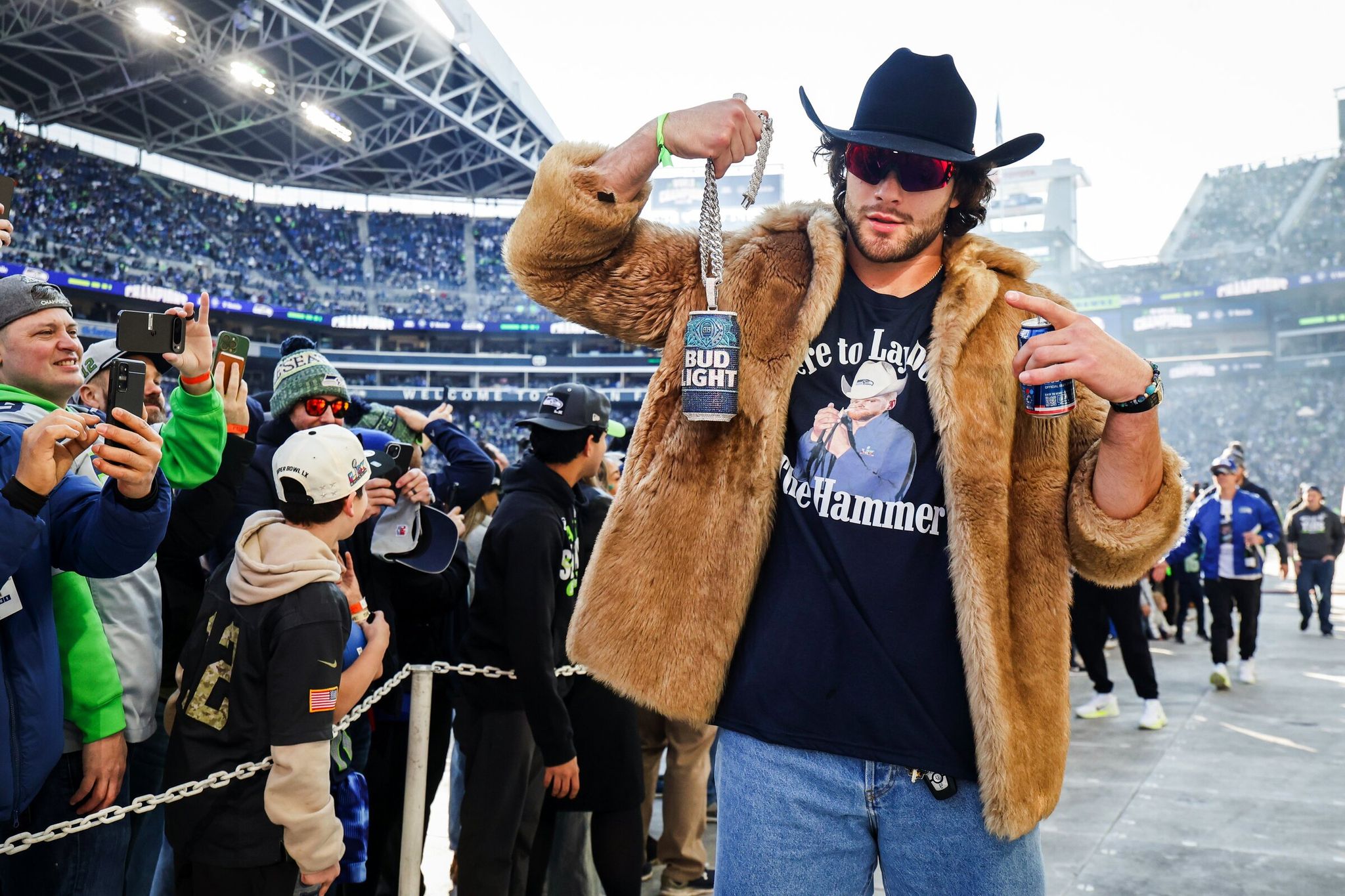 Tight end A.J. Barner lifts a Bud Light chain as the Seahawks celebrate their Super Bowl 60 win during a trophy ceremony at Lumen Field. (Dean Rutz / The Seattle Times)