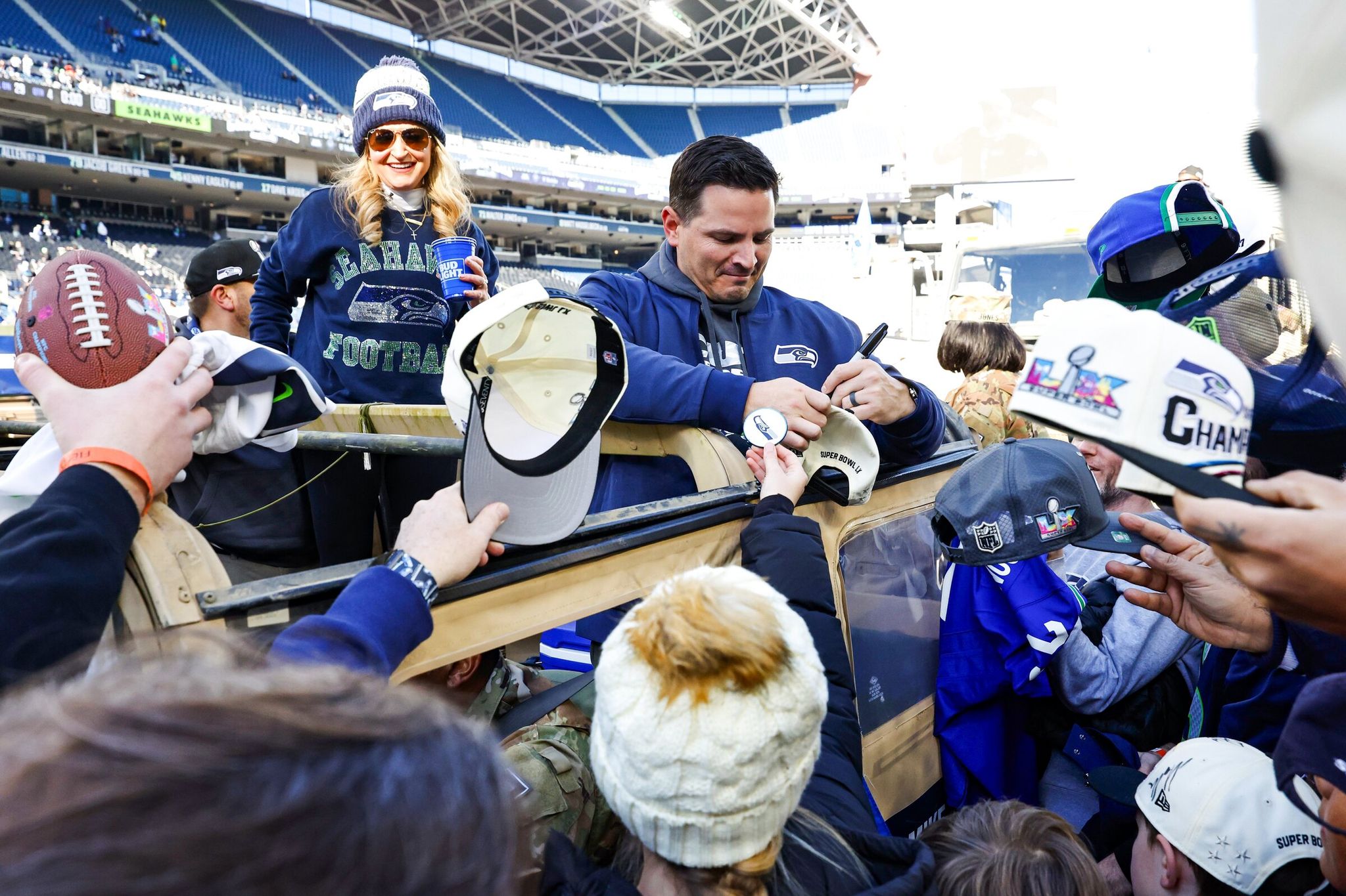 Seahawks head coach Mike McDonald signs autographs for fans after the trophy ceremony at Lumen Field, before the downtown Seattle parade. (Dean Rutz / The Seattle Times)