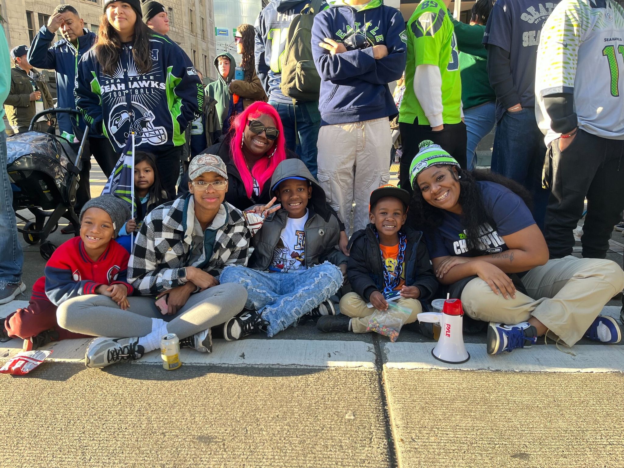 Christian Hall (right) waits with his family at the intersection of Fourth Avenue and Stewart Street along the parade route around 9 a.m. on Wednesday. (Catalina Gaitán / The Seattle Times)