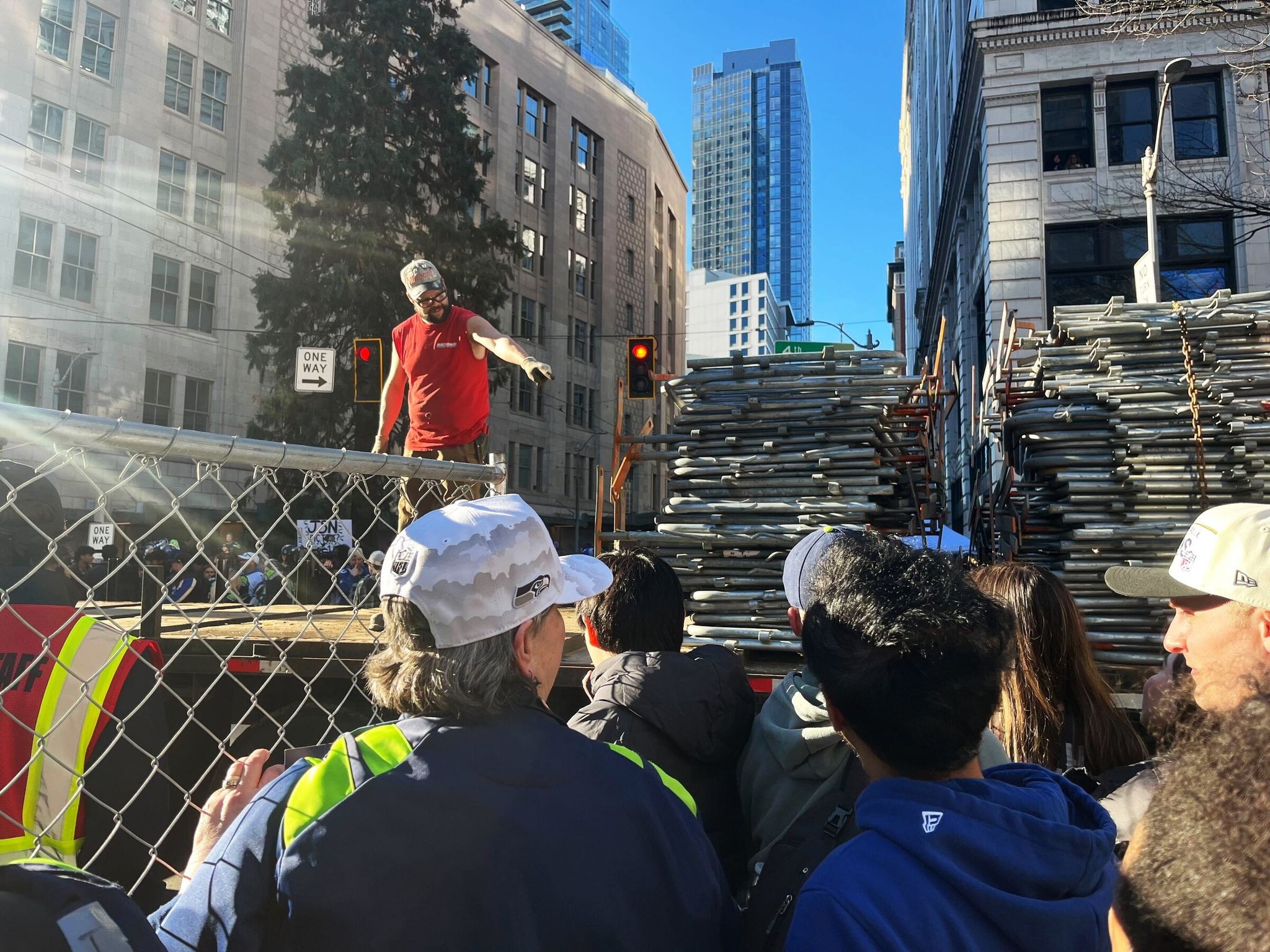 Workers removed steel barricades from a truck bed to line them along sidewalks on both sides of Fourth Avenue and Olive Way shortly before 10 a.m. on Wednesday. (Catalina Gaitán / The Seattle Times)