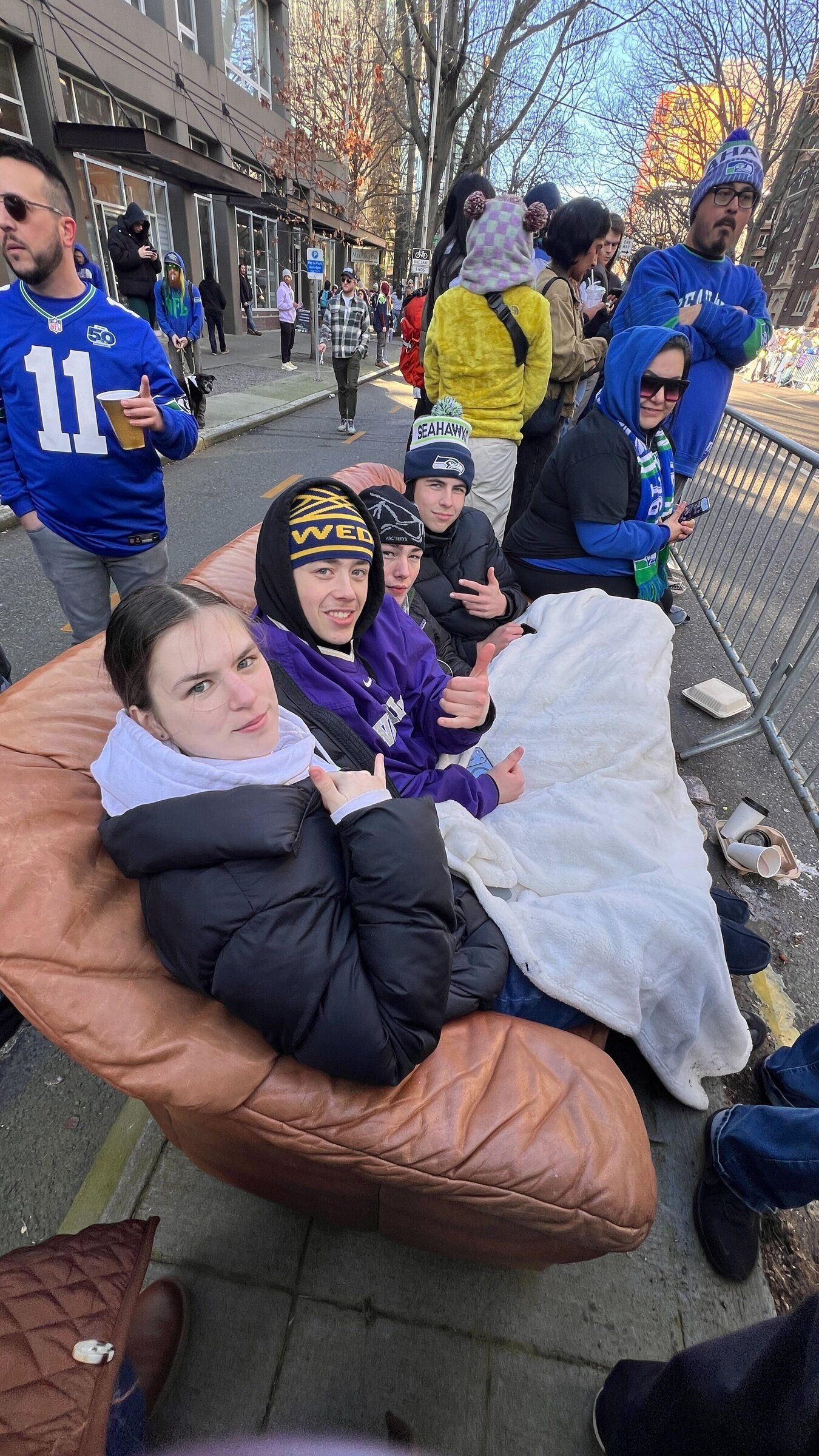 Seattle high schoolers Vivian Fresenius, 17; Sam Winjum, 18; Noel Humphrey-McLafflin, 17; and Elliot Bates, 17, made a happy discovery on their way to the parade route: a brown leather couch. (Nicole Pasia / The Seattle Times)