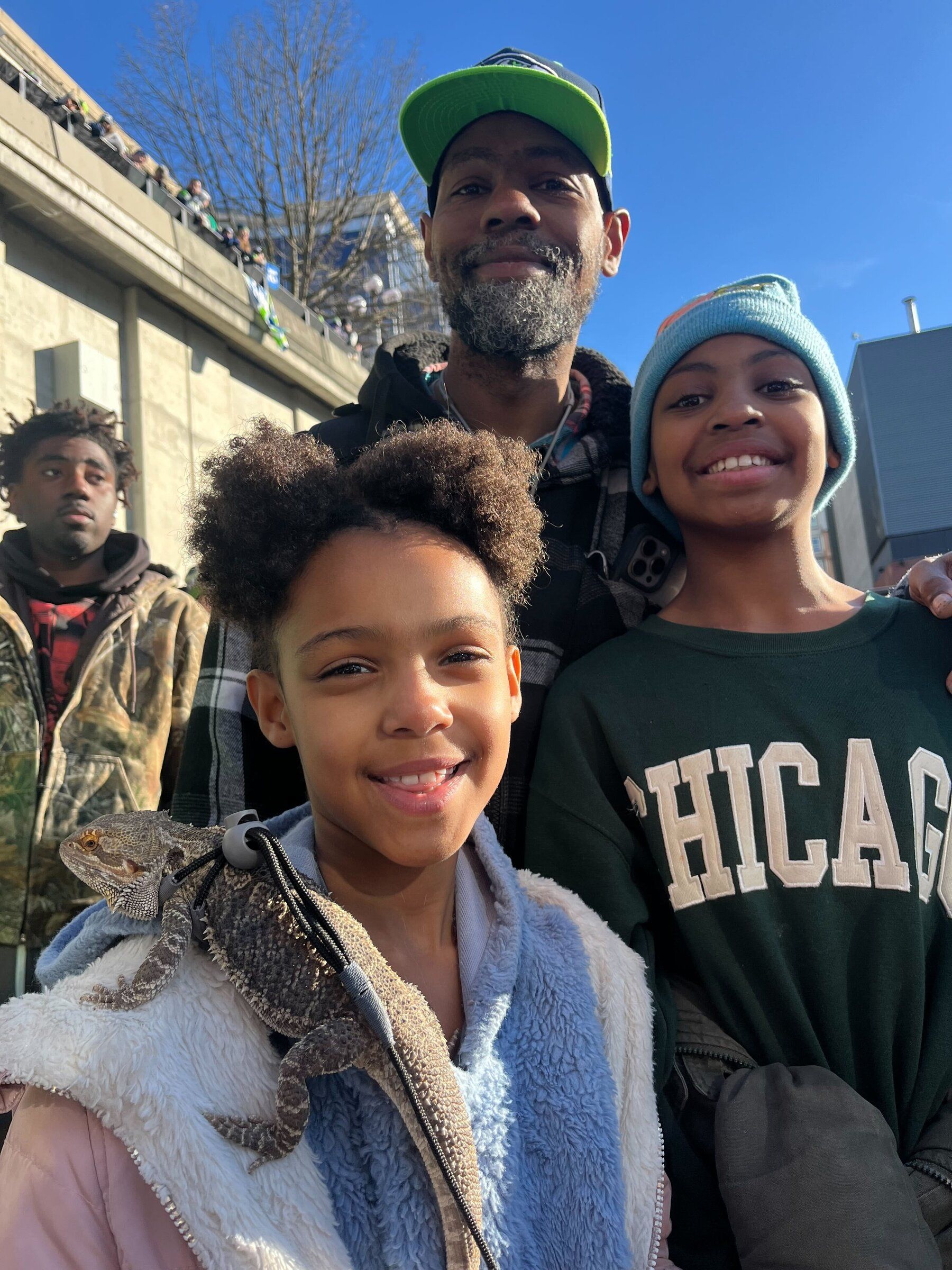 Zaily Wenga, 8, in the foreground, may be holding the Seahawks' most interesting fan — Spike Lee, the '12th lizard.' (Kai Uyehara / The Seattle Times)