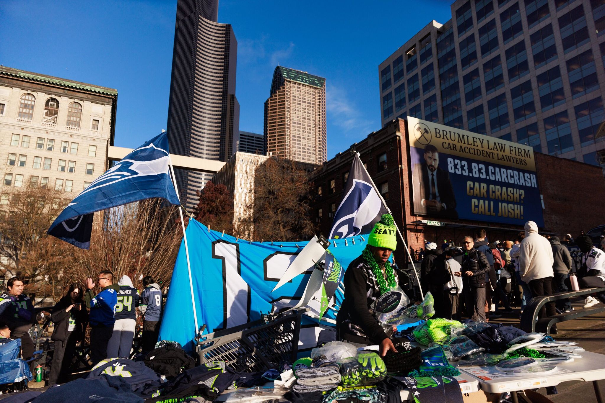 Brelan Shoemo sells Seattle Seahawks merchandise at the Seattle parade on Wednesday. (Erica Schultz / The Seattle Times)