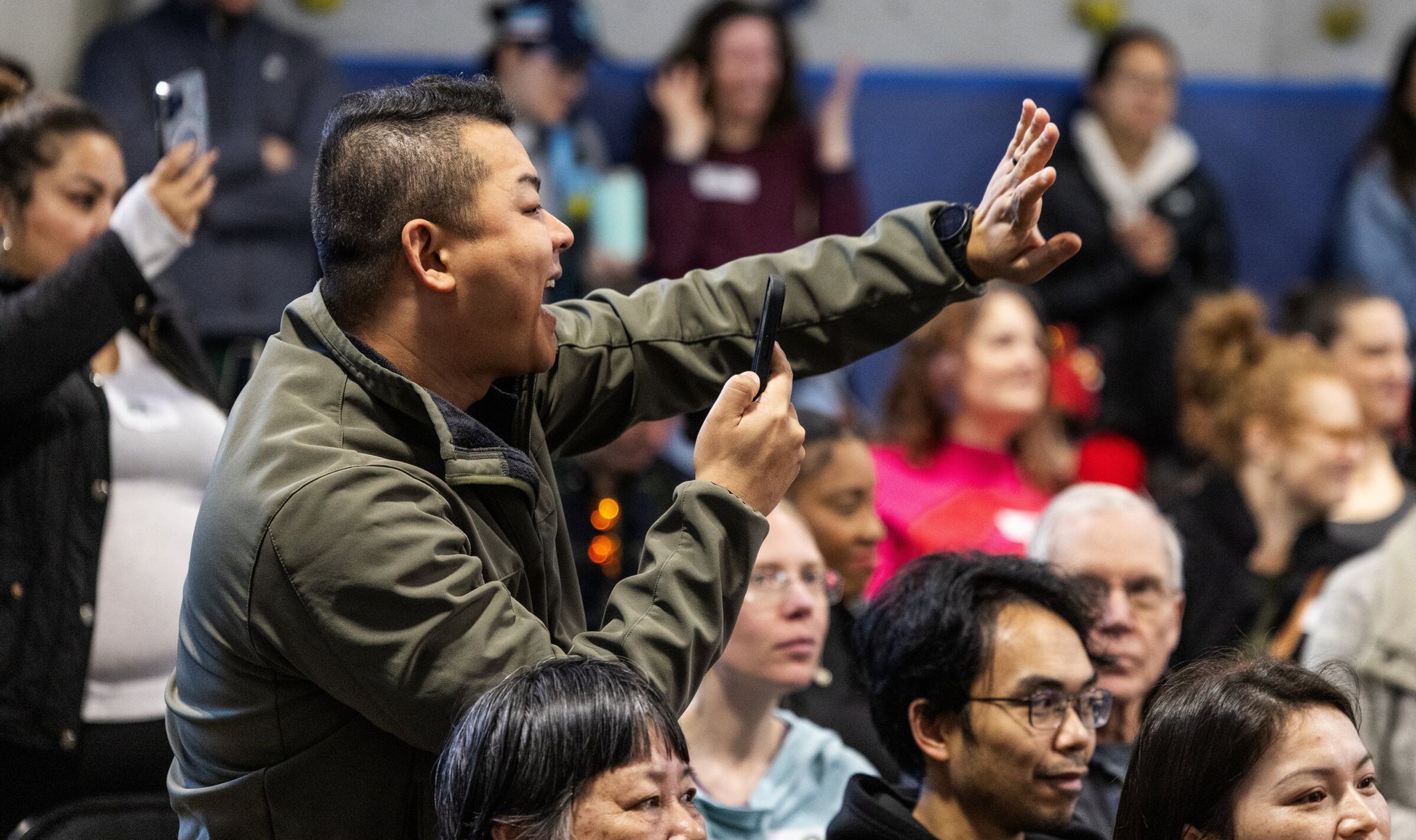 Kai Jiong Lee waves to his daughter, who is in pre-K, while she performs at the Lunar New Year celebration at Dearborn Park International Elementary on Feb. 10. (Ken Lambert / The Seattle Times)