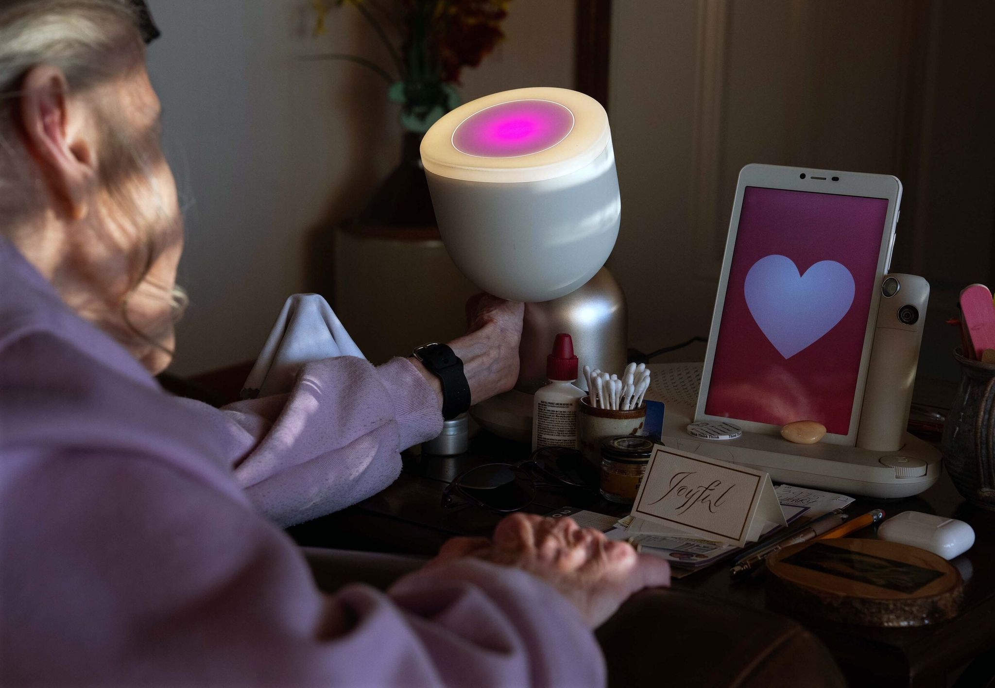 ElliQ can offer a virtual hug: it blushes and leans in toward Jan’s touch. (Ruth Fremson/The New York Times)