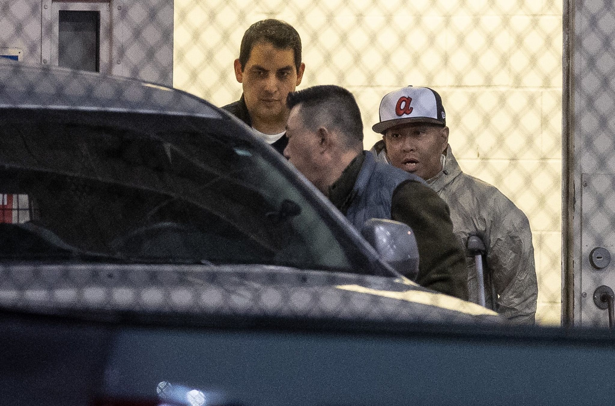 Greggy “Kuya G” Sorio, on crutches, accompanied by two men toward an SUV near the Northwest ICE Processing Center in Tacoma in December. While detained, Sorio developed a bone infection for which medical personnel amputated one of his toes and part of his foot. (Nick Wagner / The Seattle Times, 2025)