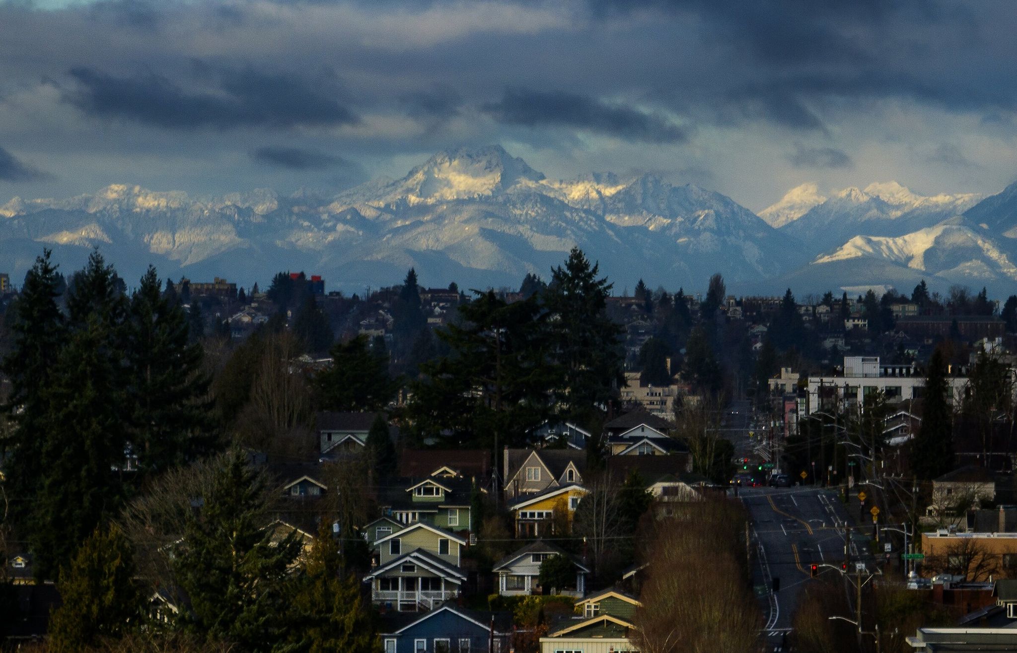 Early morning sun lights homes in Ravenna as the Olympic Mountains rise above Phinney Ridge last month. (Ken Lambert / The Seattle Times)