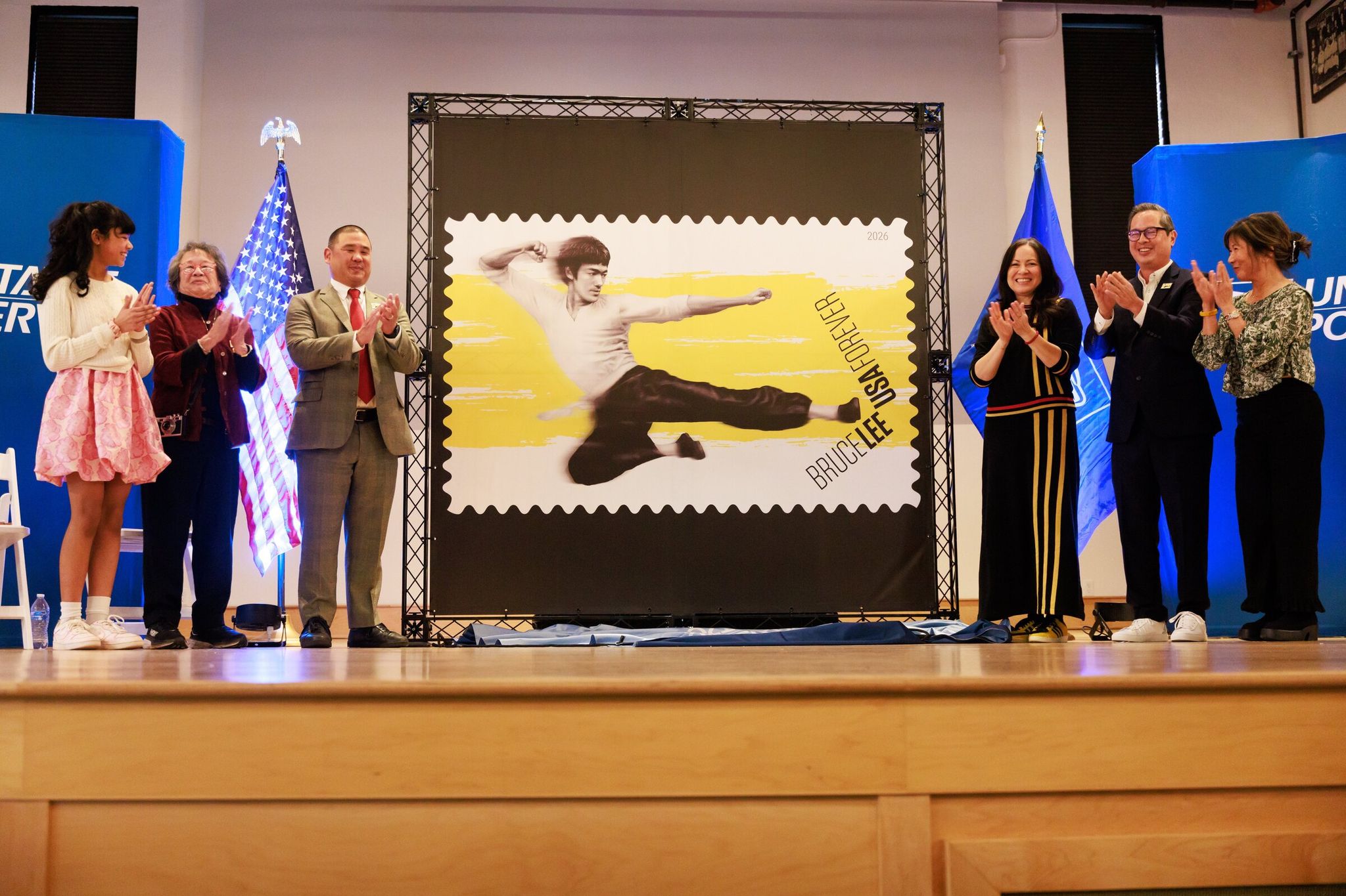 The new 'Bruce Lee Forever' stamp was unveiled at Nippon Kan theater in Seattle on Wednesday. Left to right: Janelia Lai, vocalist; Sue Ann Key, Bruce Lee’s first female student; Benjamin Kuo, USPS Senior Vice President for Facilities and Infrastructure; Shannon Lee, Bruce Lee’s daughter and CEO of Bruce Lee Enterprises; Jeff Chang, writer; and Mimi Gan, Wing Luke Museum board member. (Erika Schultz / The Seattle Times)
