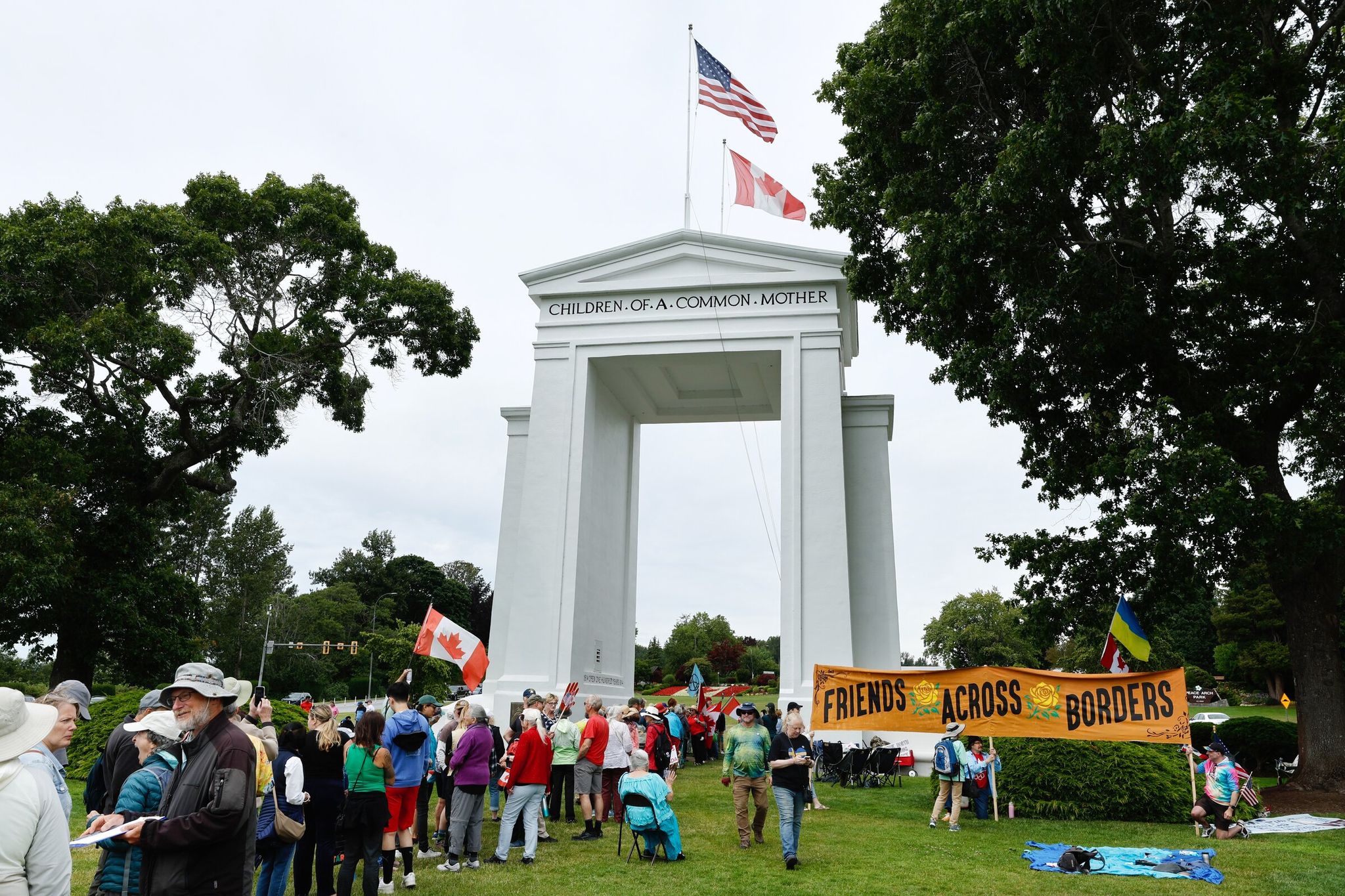 Dozens gathered under the Peace Arch on the U.S.-Canada border in Blaine for a 'Peace, Love and Handshake' rally on July 5. (Karen Ducey / The Seattle Times)