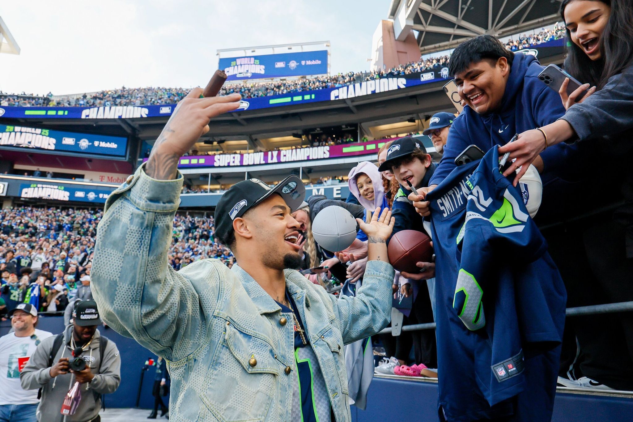 Jaxon Smith‑Njigba greets fans as he takes the field for the trophy presentation ceremony, February 11, 2026, in Seattle. (Jennifer Buchanan / The Seattle Times)