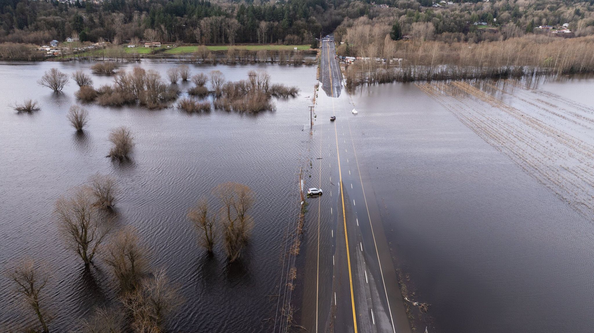 Vehicles surrounded by floodwaters on South 277th Street near Kent on Dec. 19, 2025. Restoring highways damaged by December floods is among the projects included in the new bipartisan Washington Senate proposal to allocate $1.5 billion for transportation spending. (Erika Schultz / The Seattle Times)