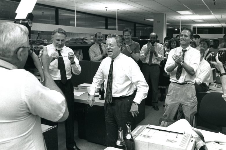 Publisher Frank Blethen, center, blinks after a celebratory Champagne shower in the Seattle Times newsroom after the 1990 Pulitzer Prize announcement. Coverage of the Exxon Valdez oil spill and its aftermath earned The Times the national reporting prize. From left: Richard Heyza (with camera), Executive Editor Mike Fancher, Blethen and reporter Eric Nalder. Behind Blethen are Steve Wainwright, Rob Kemp and reporter Duff Wilson. (Gary Settle / The Seattle Times archive, 1990)