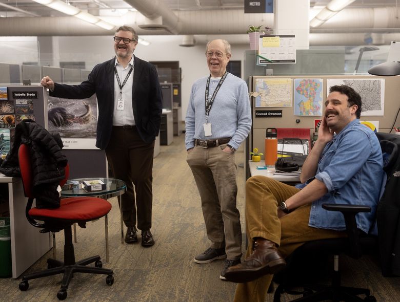 Publisher Ryan Blethen laughs in the newsroom alongside his dad and former publisher, Frank, and Seattle Times climate reporter Conrad Swanson, right. (Nick Wagner / The Seattle Times)
