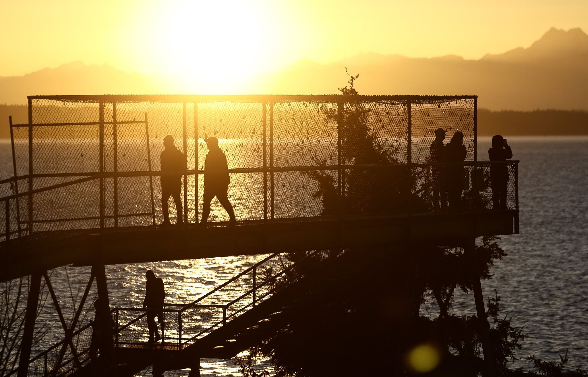 People take in a clear-sky sunset at Carkeek Park beach in Seattle last weekend. (Nick Wagner / The Seattle Times)