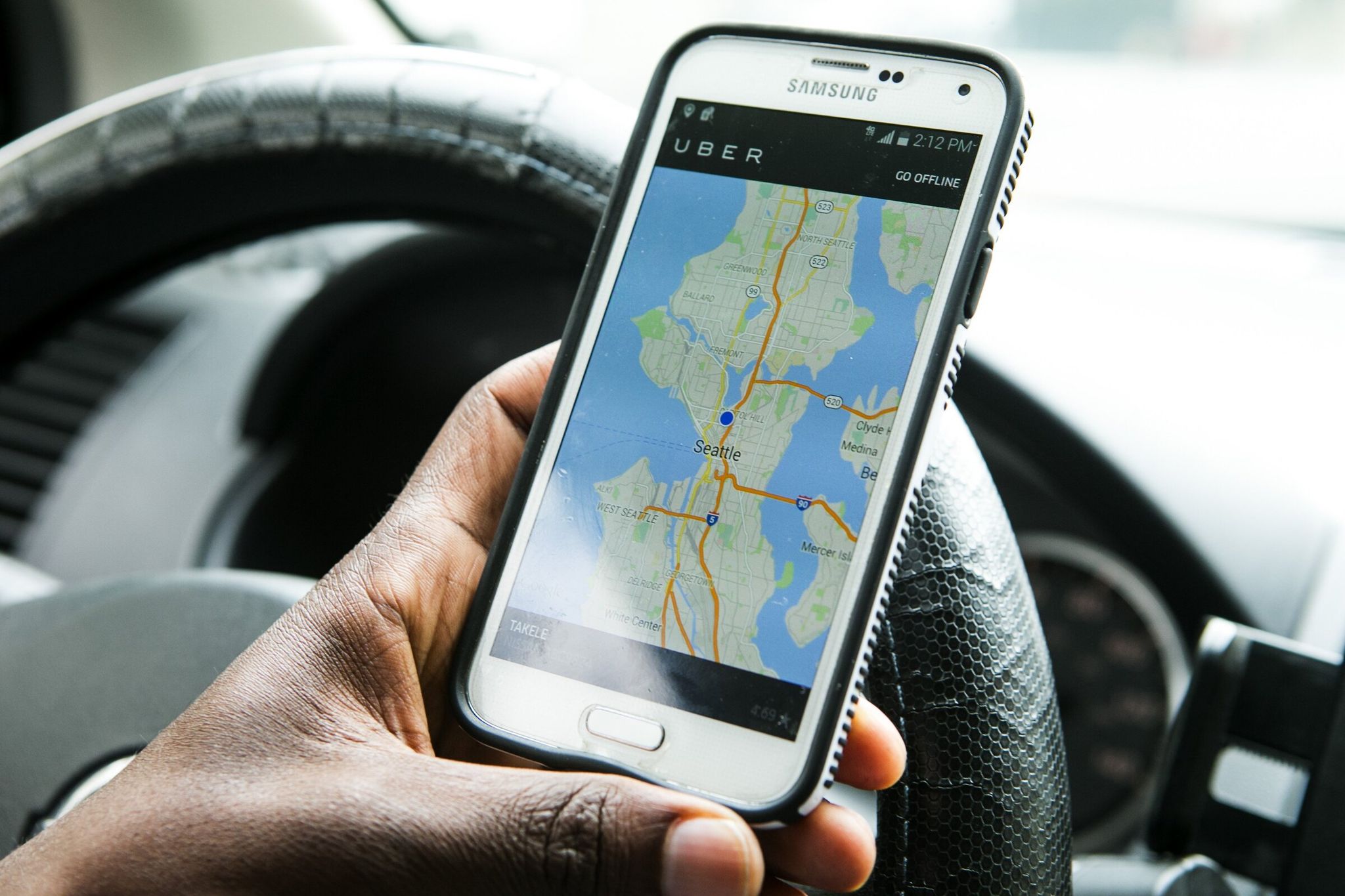 Takele Gobena, 26, of SeaTac, shows how the driver’s side of the app Uber works for picking up riders Monday August 31, 2015. (Bettina Hansen / The Seattle Times)