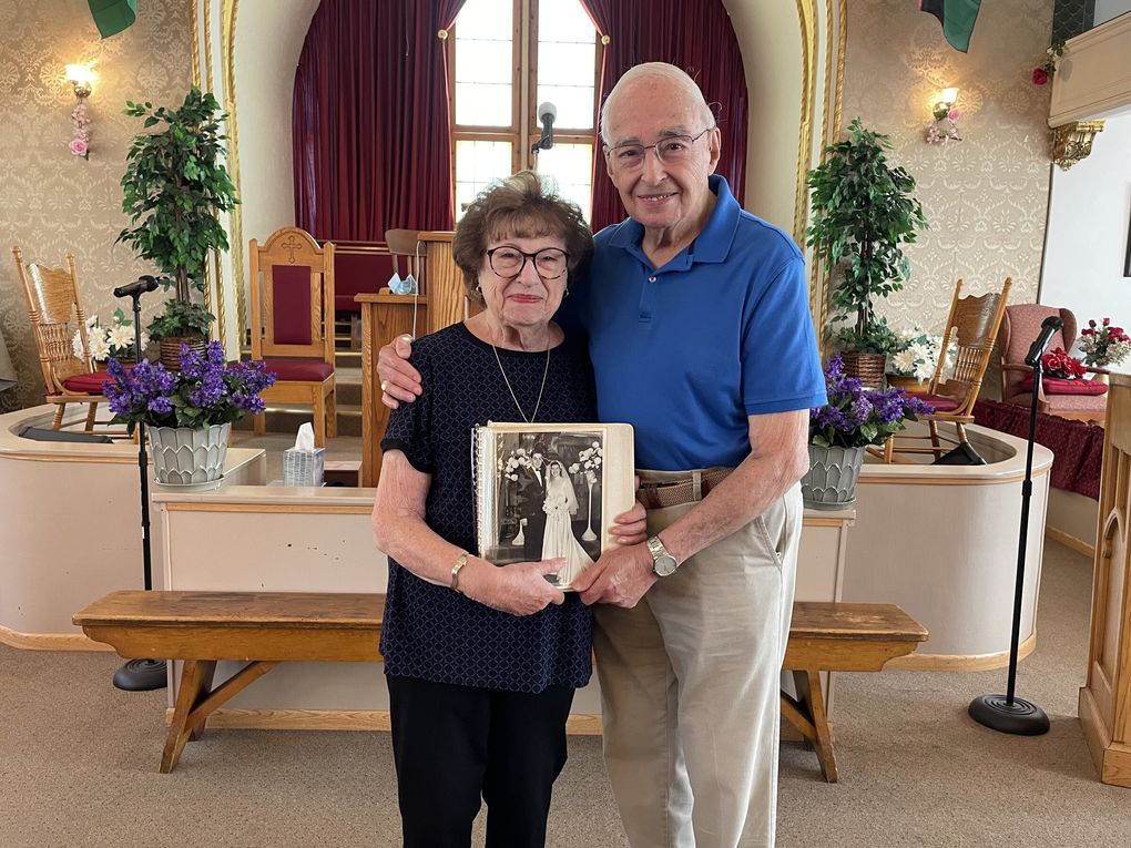 Regina and Victor C. Amira hold their wedding album inside Tolliver Temple Church of God in Christ during the launch of the Seattle Historic Sephardic Tour on July 25, 2021. They were married inside the historic building, when it was the Sephardic Bikur Holim synagogue. (Courtesy of Washington State Jewish Historical Society) 