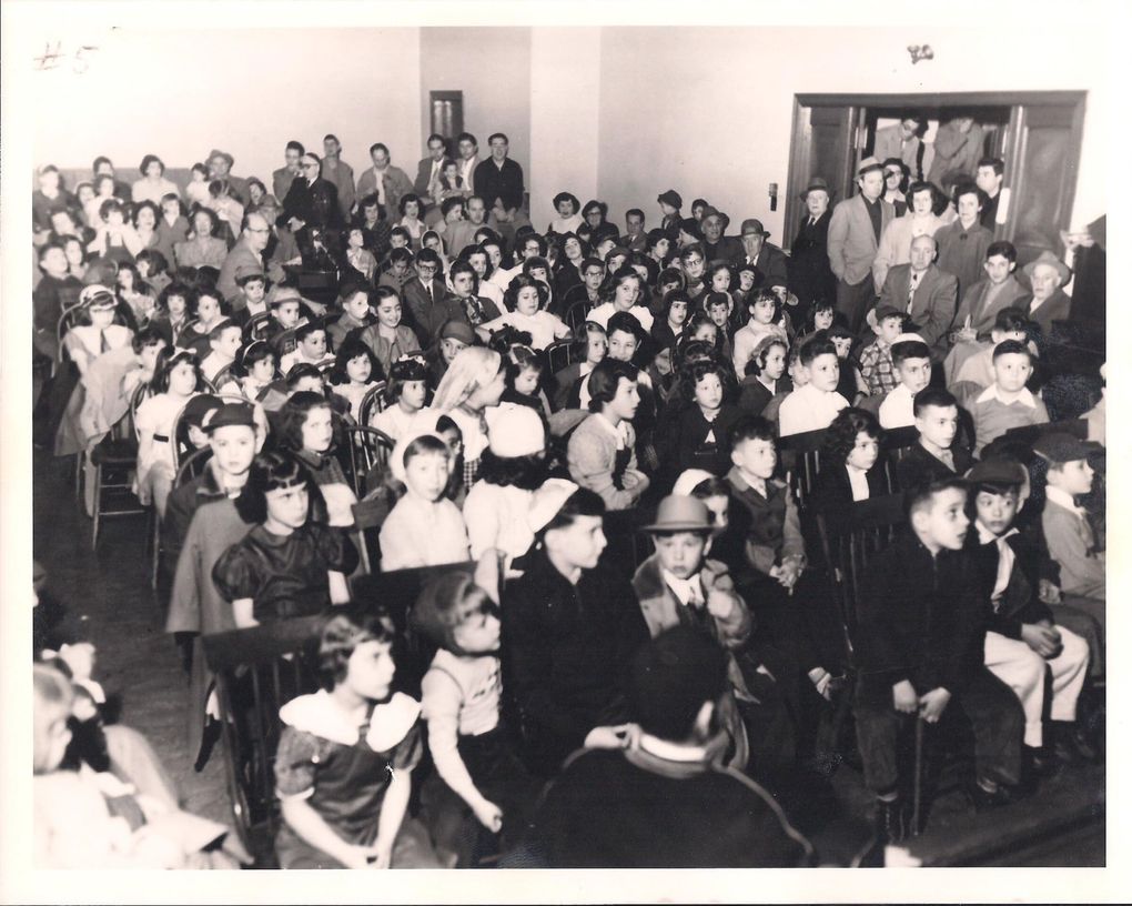 The congregation of Sephardic Bikur Holim gathers in the early 1950s, when the synagogue was located in the Central District. Many of the children, including Joel Benoliel (second row center, hands folded in his lap), are there to see a movie. (Courtesy of Joel Benoliel)