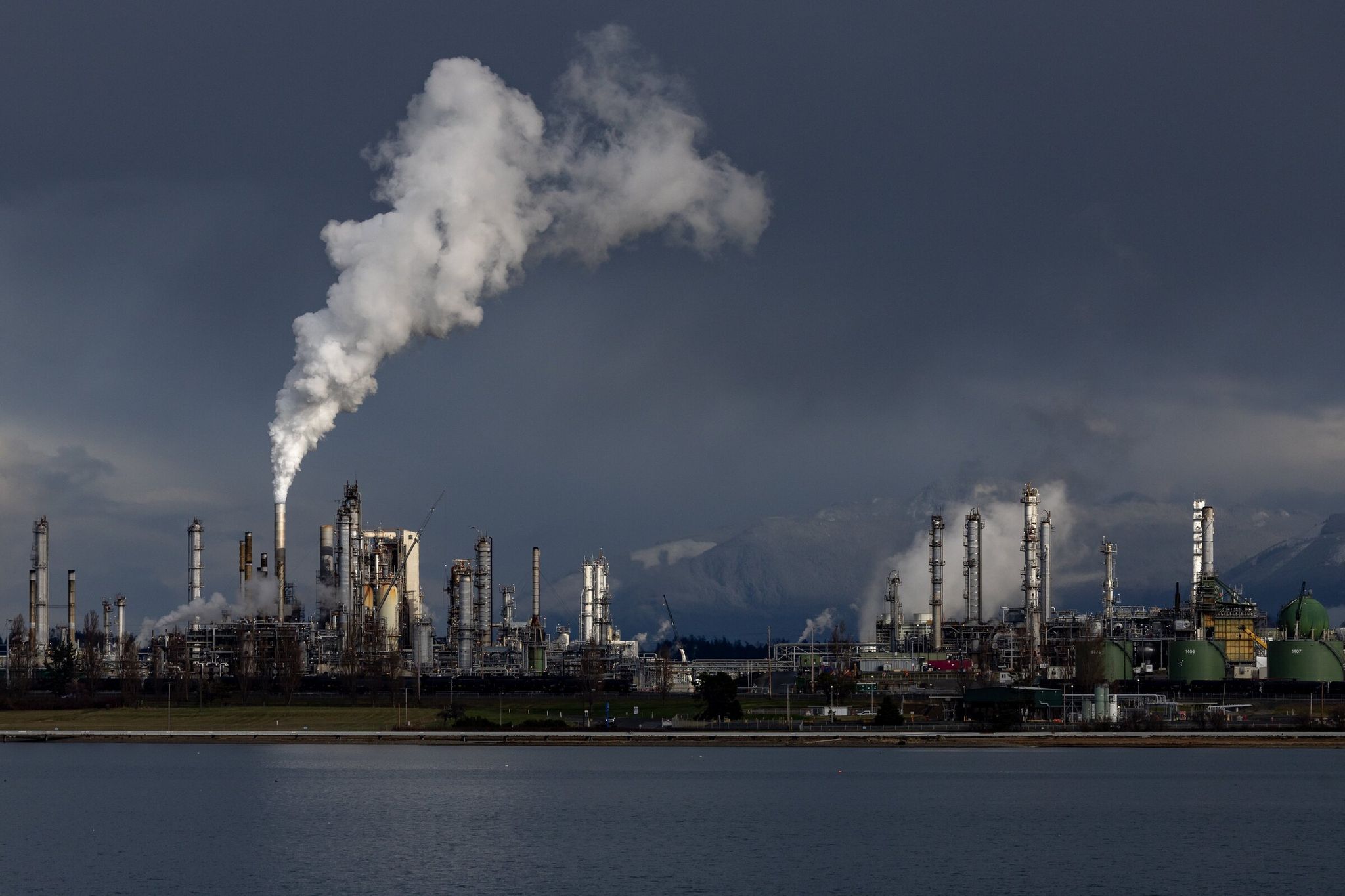 The waters of Fidalgo Bay lay quiet as winter sunlight illuminates Marathon Petroleum’s refinery at March Point. (Jennifer Buchanan / The Seattle Times, 2023)