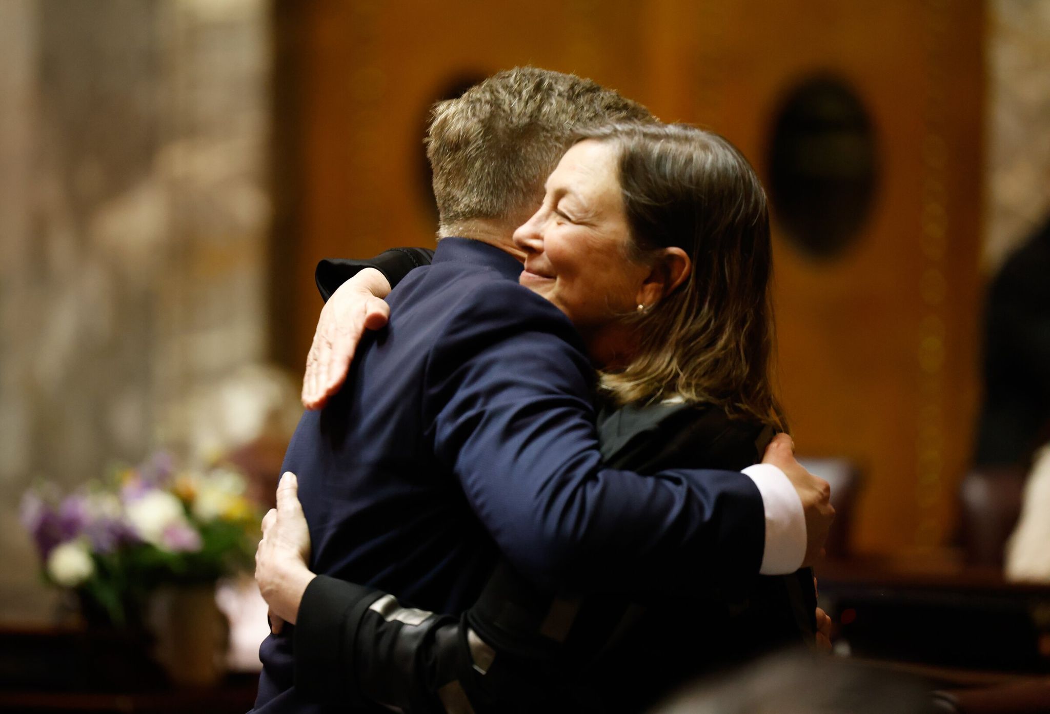 Сенатор Джейми Педерсен (демократ, Сиэтл), слева, обнимает сенатора Джун Робинсон (демократ, Эверетт), руководителя бюджета сенатских демократов. Сенат голосует по законопроекту о налоге на миллионеров, принятому Палатой представителей прошлой ночью, в Государственном капитолии в Олимпии в среду, 11 марта 2026 года. (Карен Дюси / The Seattle Times)