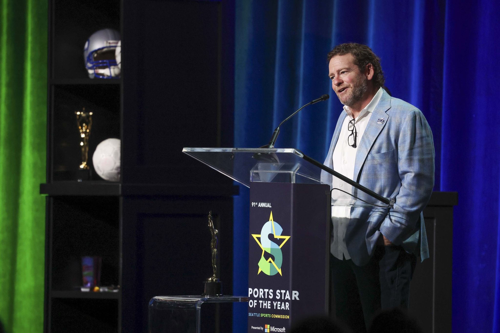 Legacy of Sports Leadership award winner John Schneider speaks at the 91st annual Seattle Sports Star of the Year Awards in the Summit hall of the Seattle Convention Center in downtown Seattle on Friday, March 13, 2026. (Ivy Ceballo / The Seattle Times)