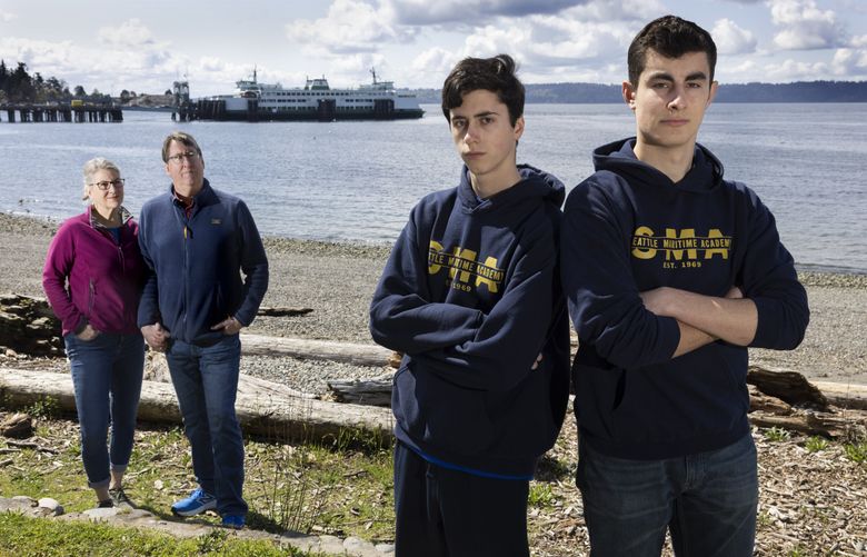 From left, Darcy Birkeland and Jevon Powell with their son Eli Powell and his classmate Jack Chiodo Jr., from Maritime High School, near the Fauntleroy Ferry Terminal in West Seattle. (Ellen M. Banner / The Seattle Times, 2025)