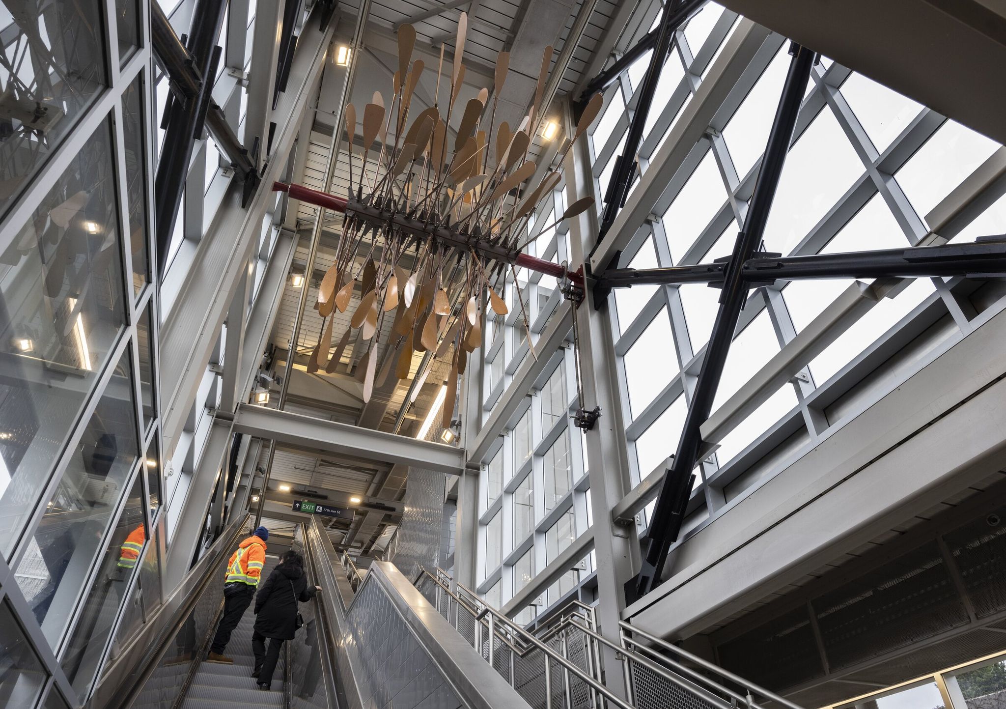 Tom Eichele, Sound Transit facilities manager, left, and Rachael Cunningham, Sound Transit spokeswoman, walk past the artwork Beliz Brother, leaving the west end of Mercer Island station. (Ellen M. Banner / The Seattle Times)