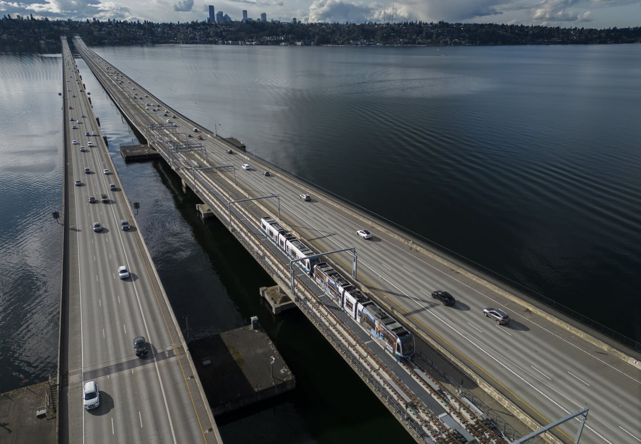 A test train travels across the floating I-90 bridge with Seattle in the background. Light rail will finally cross Lake Washington, connecting Seattle with the Eastside starting Saturday. (Ellen M. Banner / The Seattle Times)