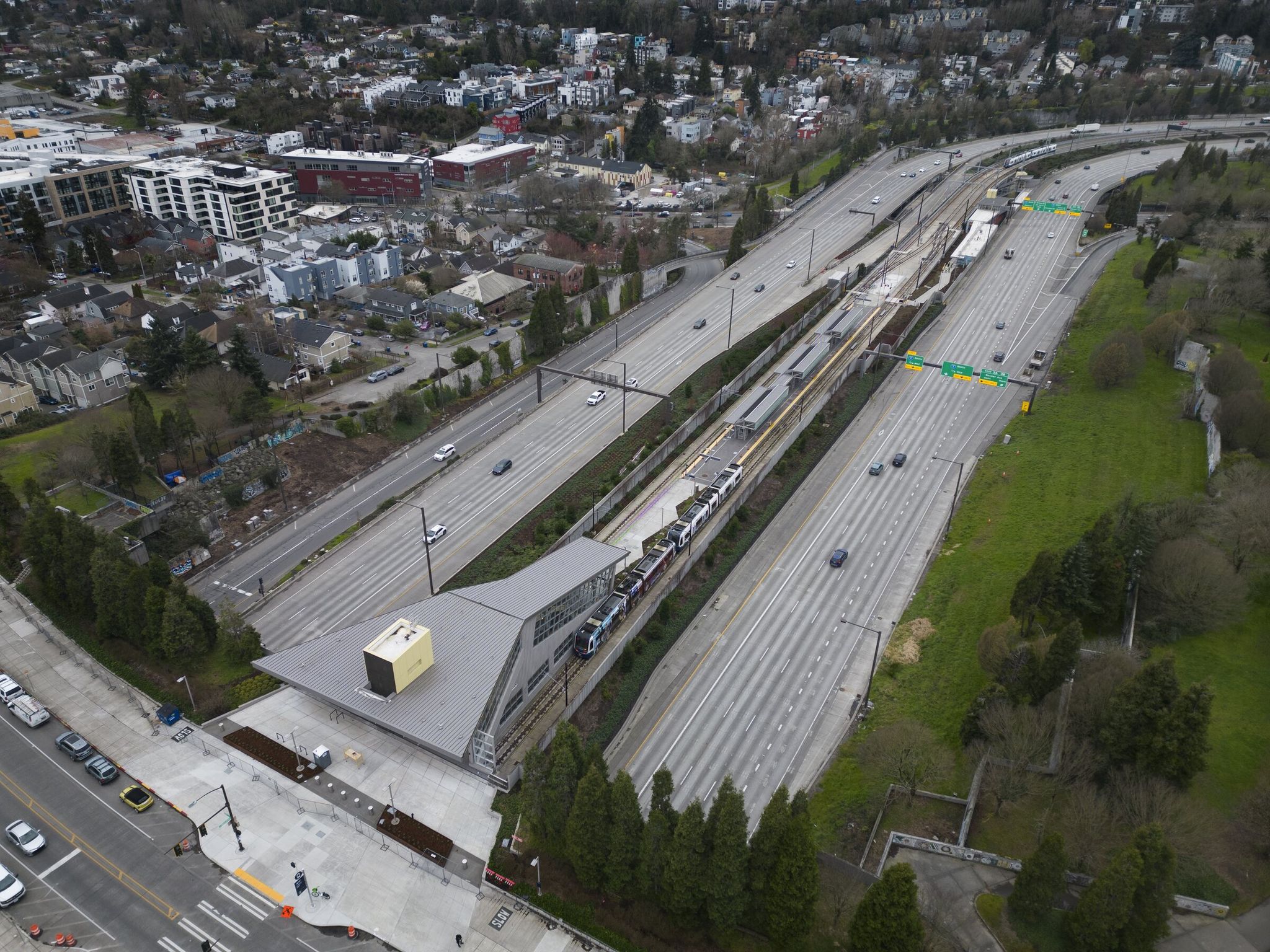 A light-rail train arrives at Judkins Park station during a training run; the upper entrance opens onto South 23rd Avenue. (Ellen M. Banner / The Seattle Times)