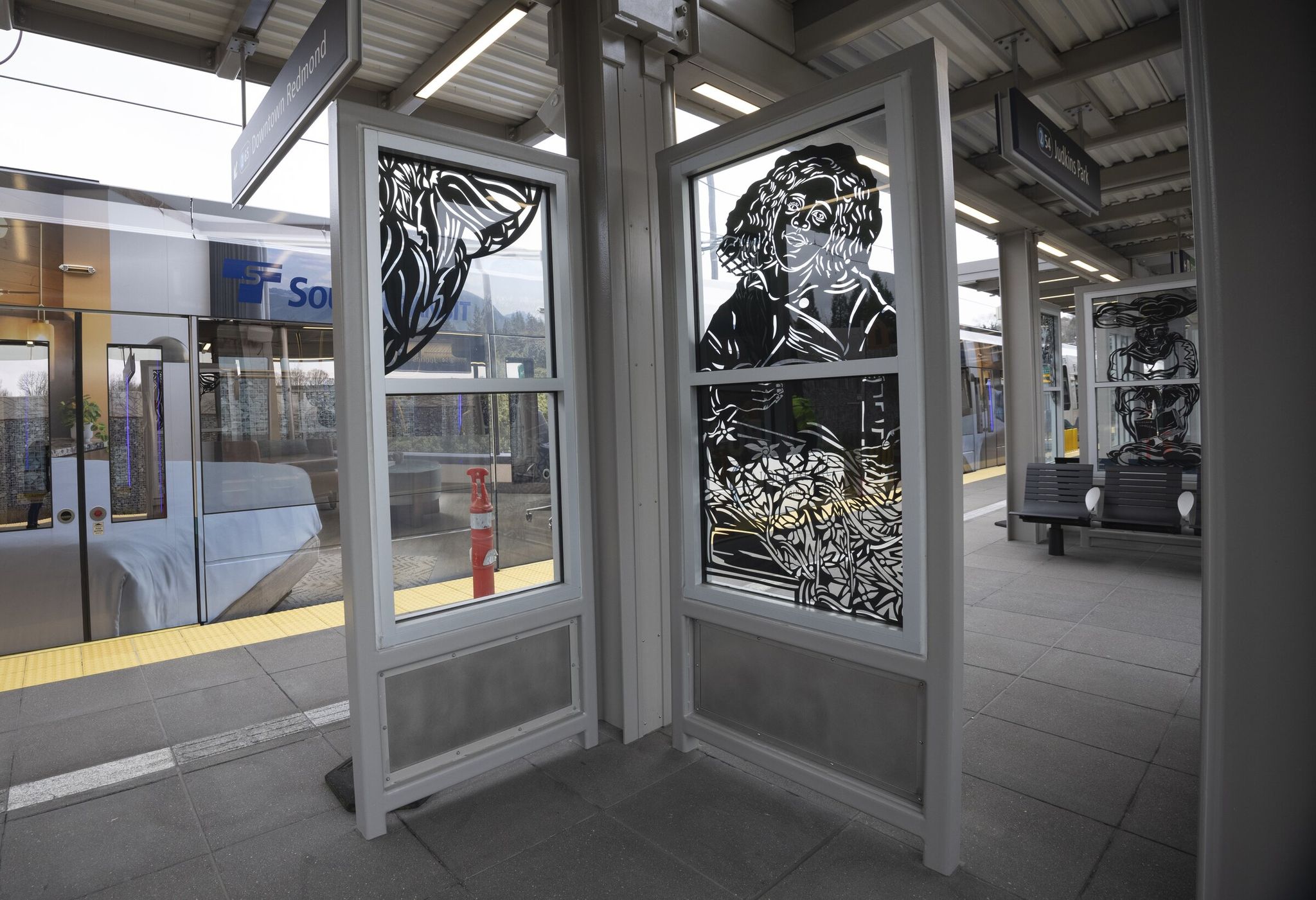 Artwork on the platform glass panels by Seattle artist Barbara Earl Thomas tells stories at Judkins Park station. Thomas translated her paper-cut images into glass and metal. (Ellen M. Banner / The Seattle Times)
