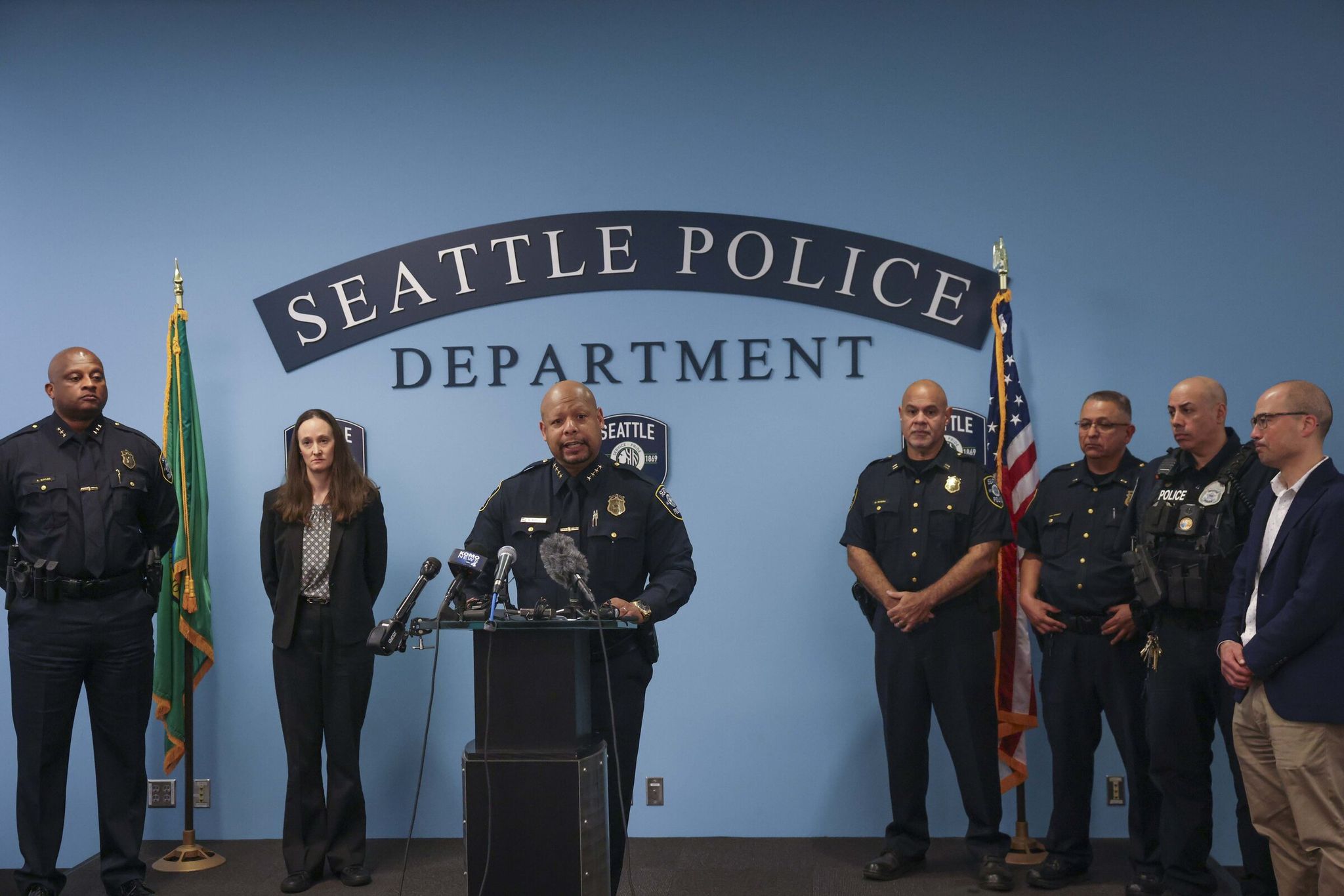 Chief Shon Barnes, center, speaks with members of the media at the Seattle Police Department headquarters on Tuesday. Police announced an arrest was made in the January killing of two teenagers at a Rainier Valley bus stop. (Ivy Ceballo / The Seattle Times)