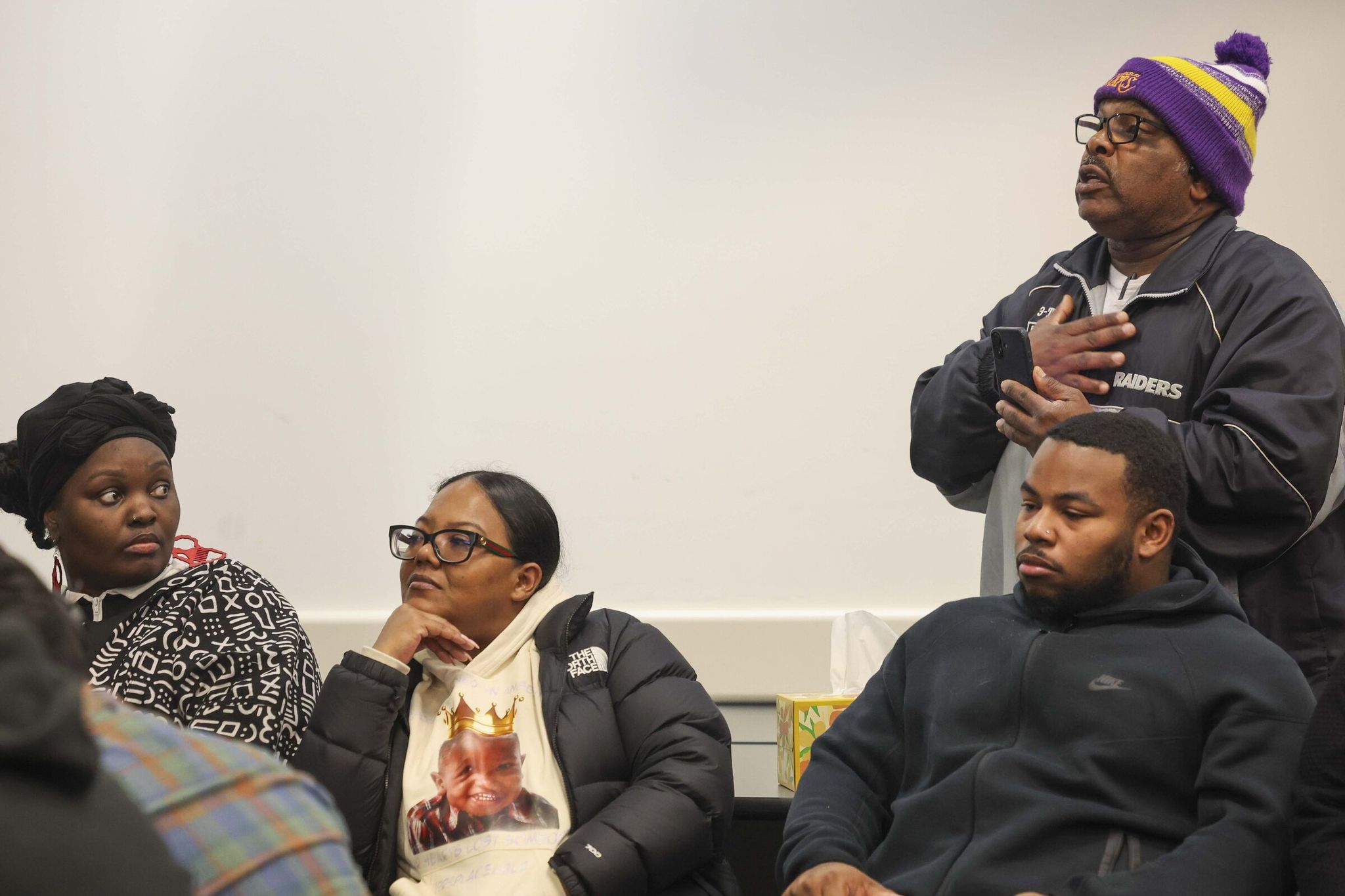 A community member speaks with Seattle Police Chief Sean Barnes at a Tuesday news conference. Family members of the teens who were shot are present at the event. (Ivy Seballo / The Seattle Times)