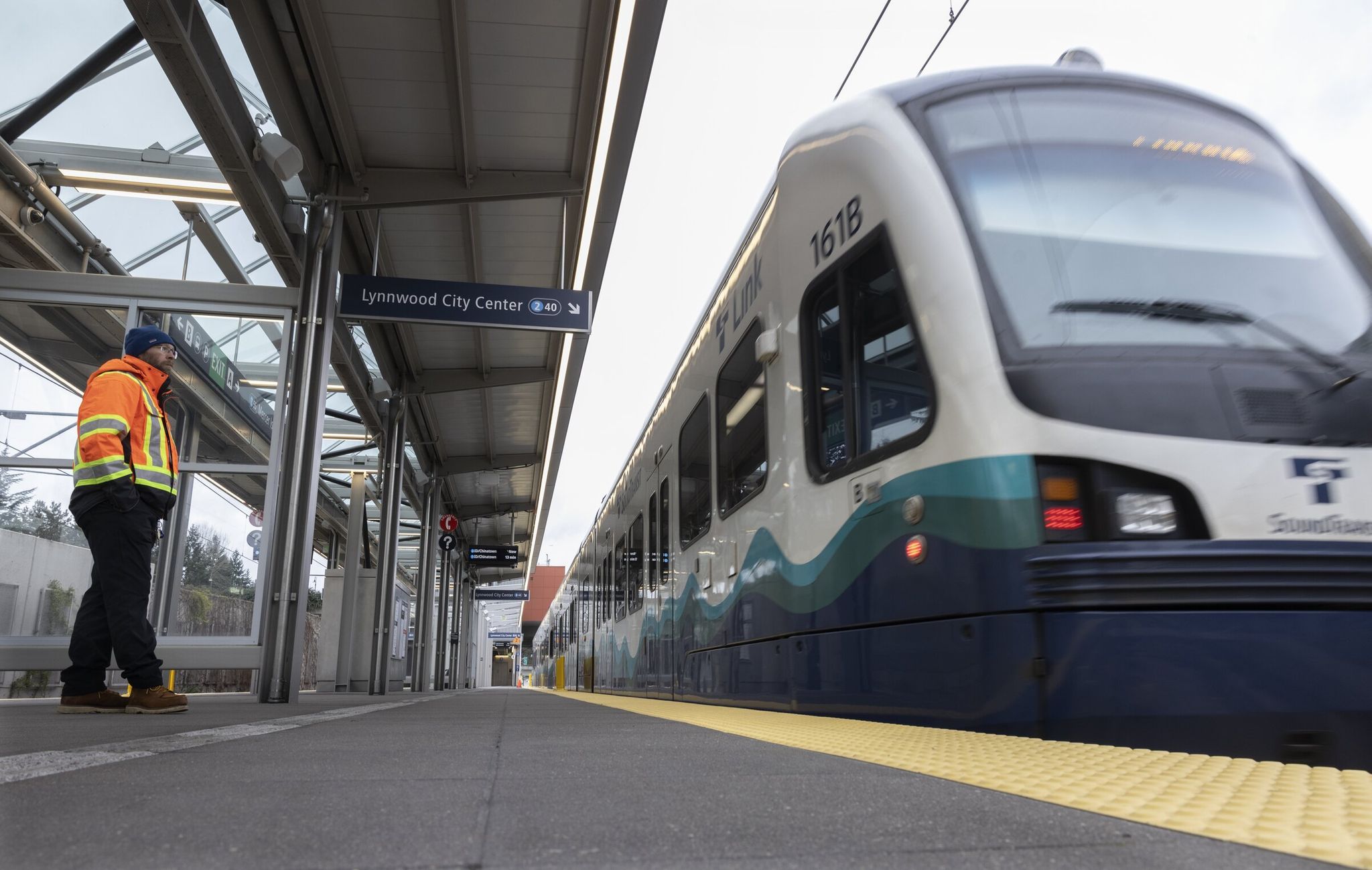 Tom Aichele, facilities manager at Sound Transit, watches a light-rail train move west through Mercer Island station, a new stop on Line 2. (Ellen M. Banner / The Seattle Times)