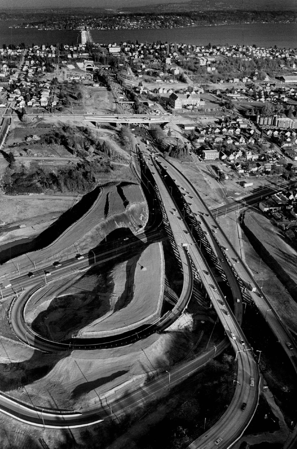 March 4, 1986: Buildings have been razed and ramps built for I-90 near Rainier Avenue South. In the background are Mercer Island and Lake Washington. (Craig Fujii / The Seattle Times)