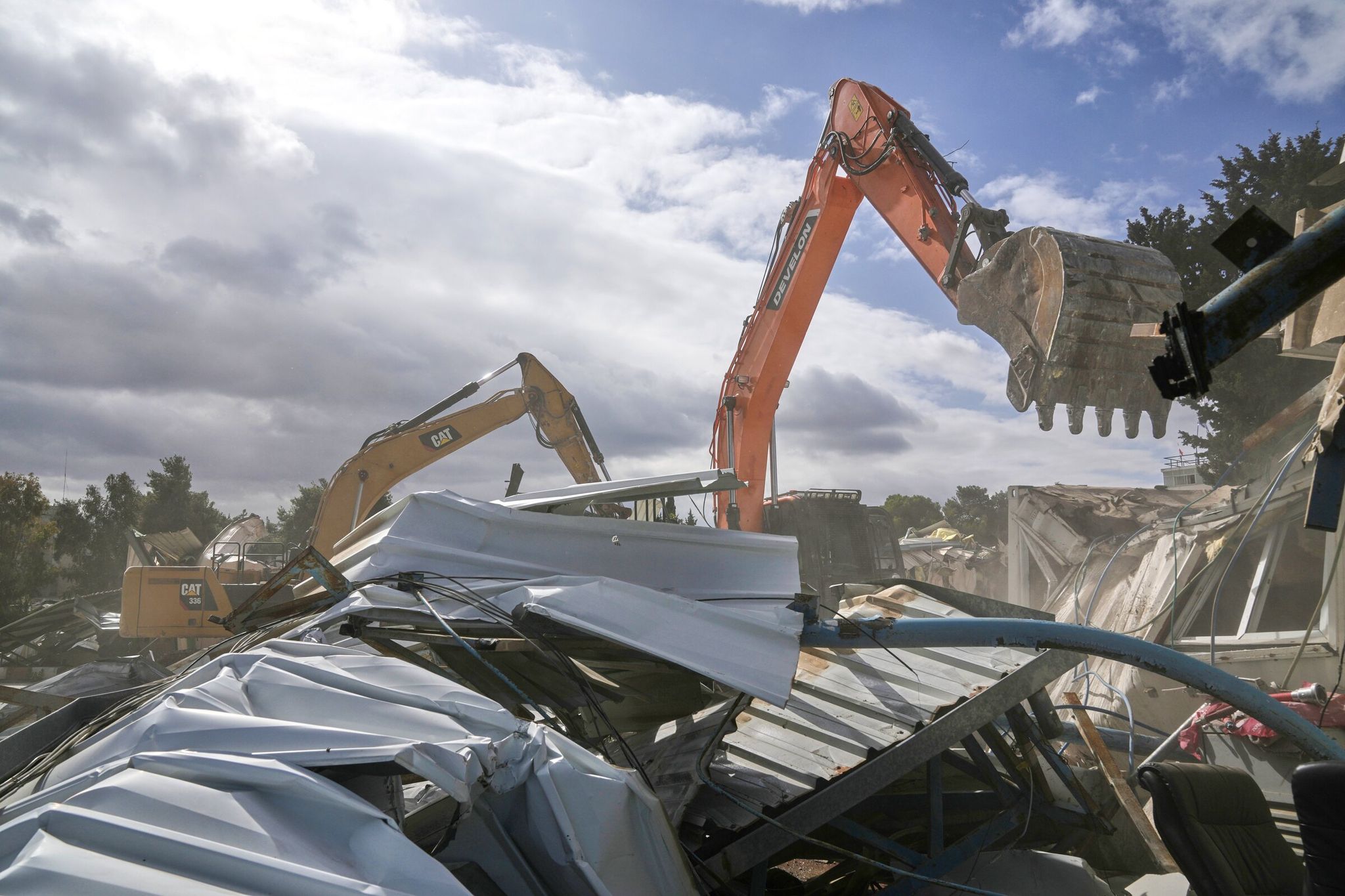 Israeli bulldozers, including one branded Caterpillar at left, demolish an area belonging to a UN agency that helps Palestinian refugees in East Jerusalem in January. (Mahmoud Illean / The Associated Press)