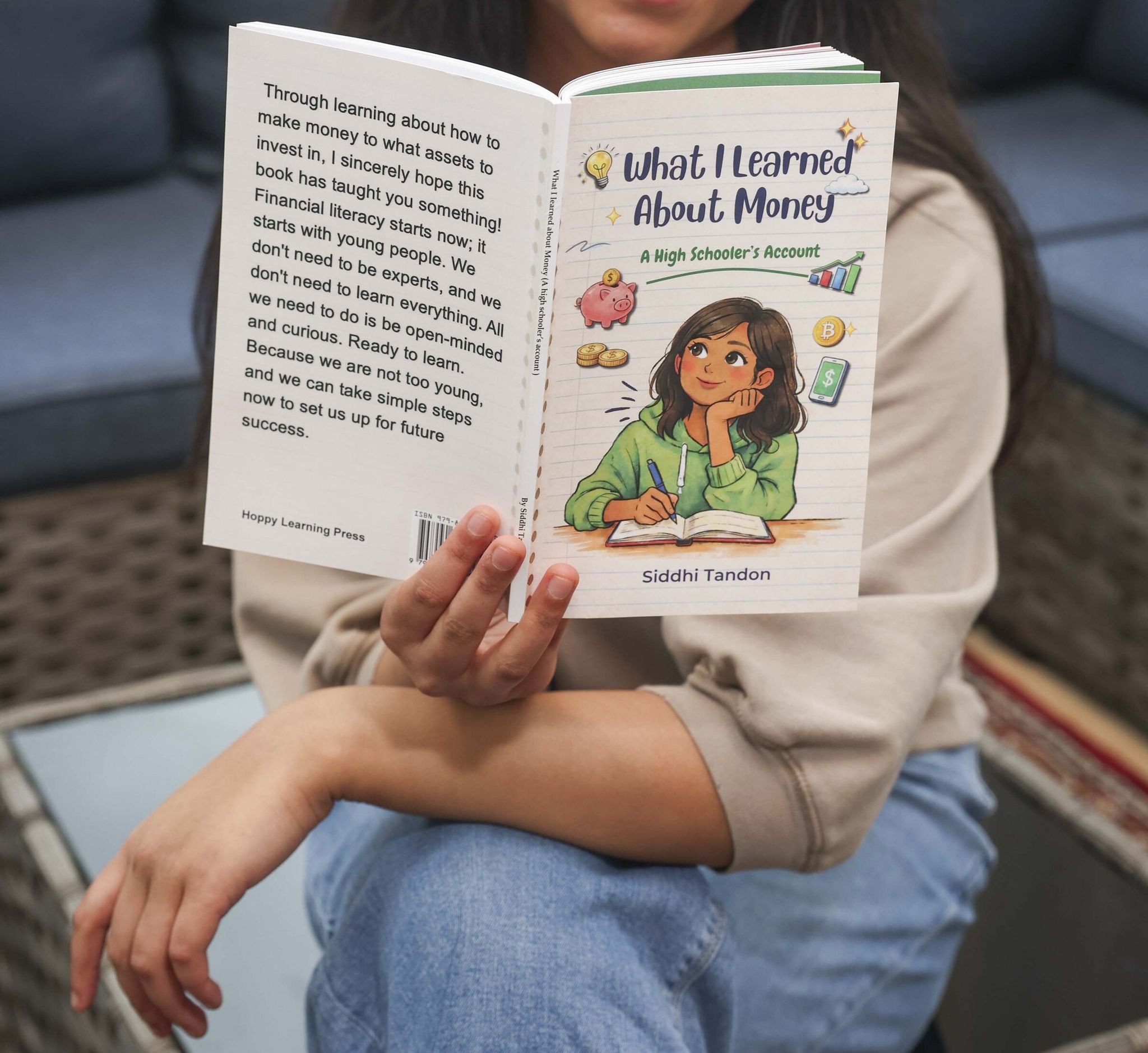 Siddhi Tandon, 17, poses with her book What I Learned About Money. (Ivy Ceballo / The Seattle Times)
