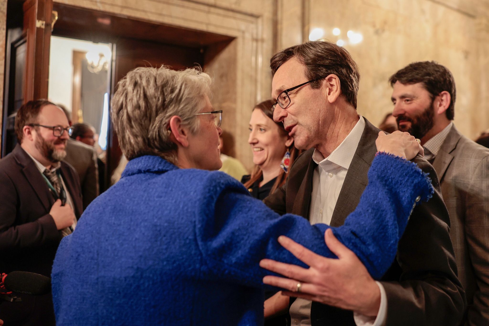 Governor Bob Ferguson hugs Rep. Laurie Jinkins, Speaker of the House, after the passage of the ‘millionaires’ tax’ in the Capitol building in Olympia earlier this month. (Karen Ducey / The Seattle Times)